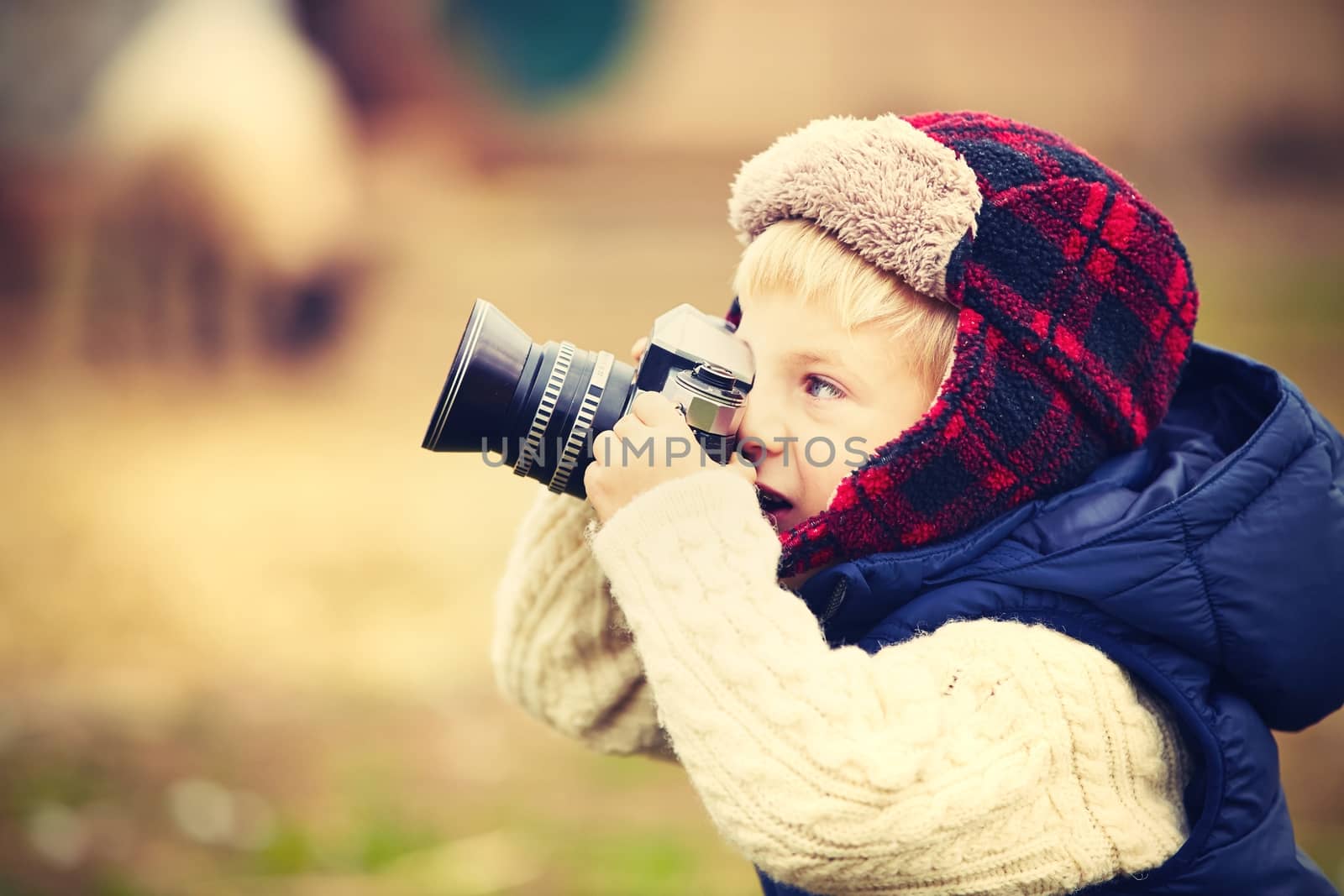 Little boy with camera is shooting in the farm