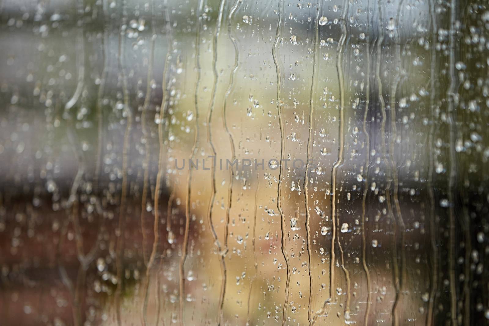 Little boy behind the window in the rain - selective focus