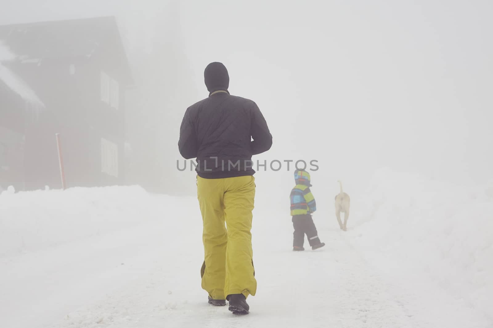 Father with son are walking in mountains in winter