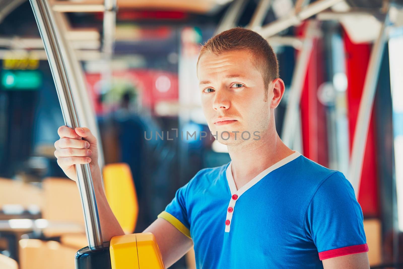 Everyday life and commuting to work by public transportation. Handsome young man is traveling by bus (tram). 