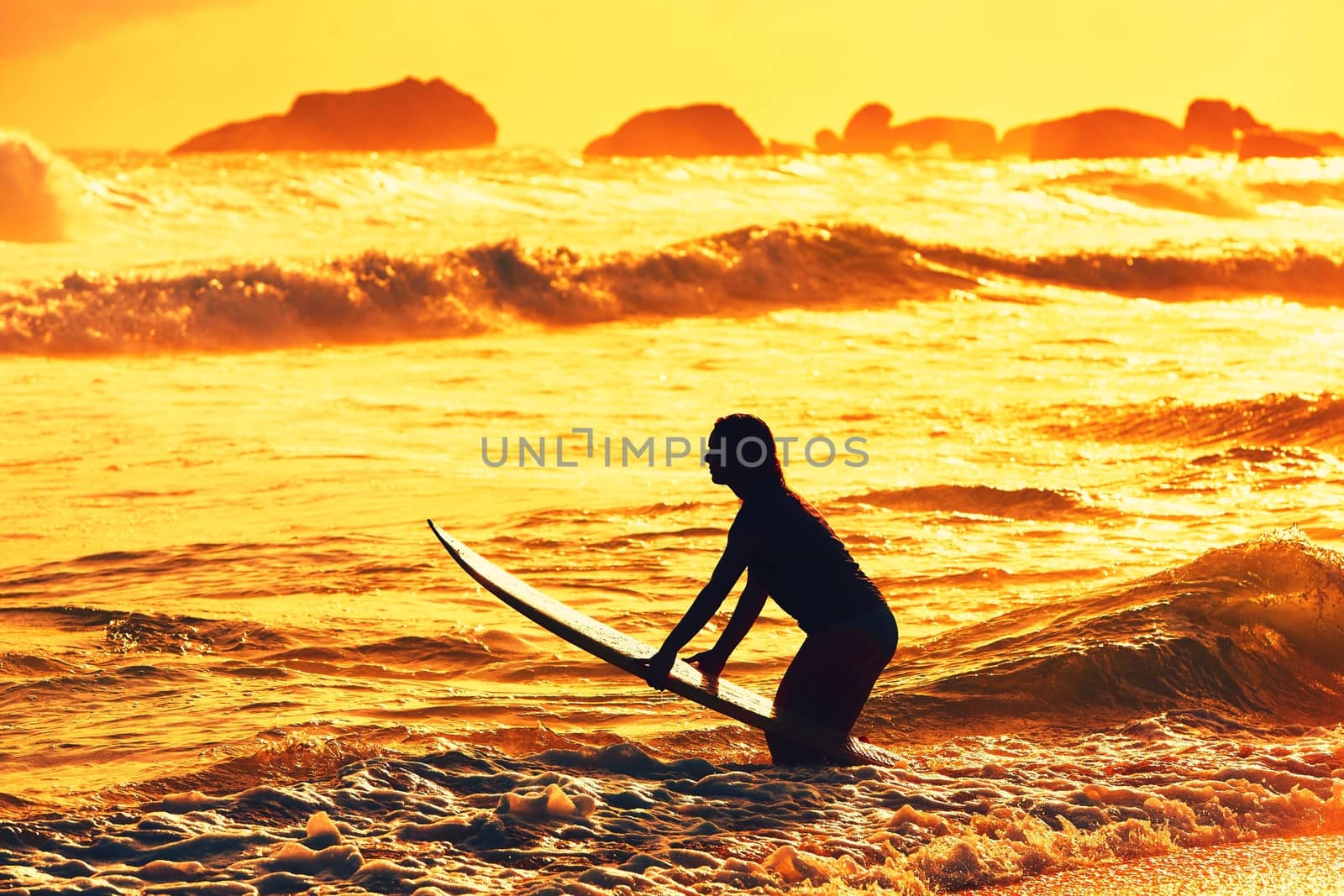 Silhouette of the beautiful surfer girl is enjoying vacation on the tropical beach. Young woman with surfboard at golden sunset. Sri Lanka. - back lit
