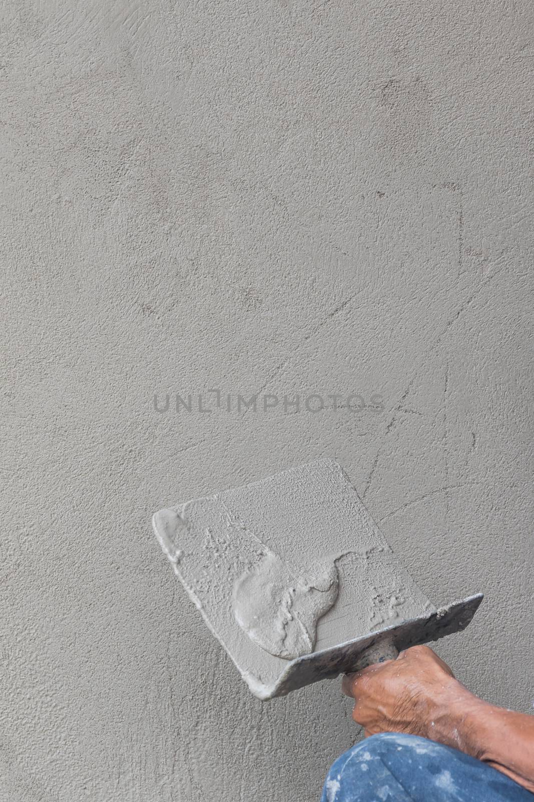 Builder worker plastering concrete  at wall of house construction