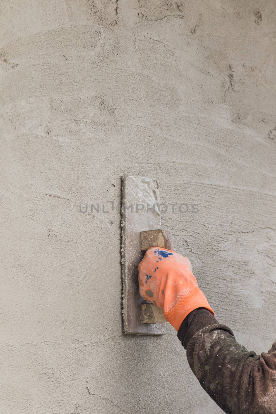 Builder worker plastering concrete  at wall of house construction