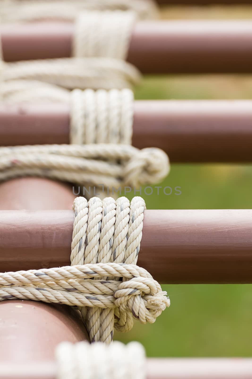 Close up of rope tied knot around metal pipe