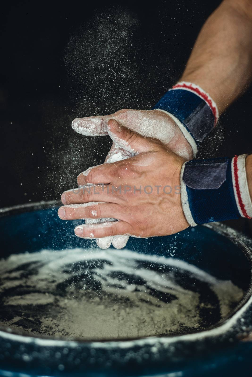 Chalking hands to prepare for weightlifting.