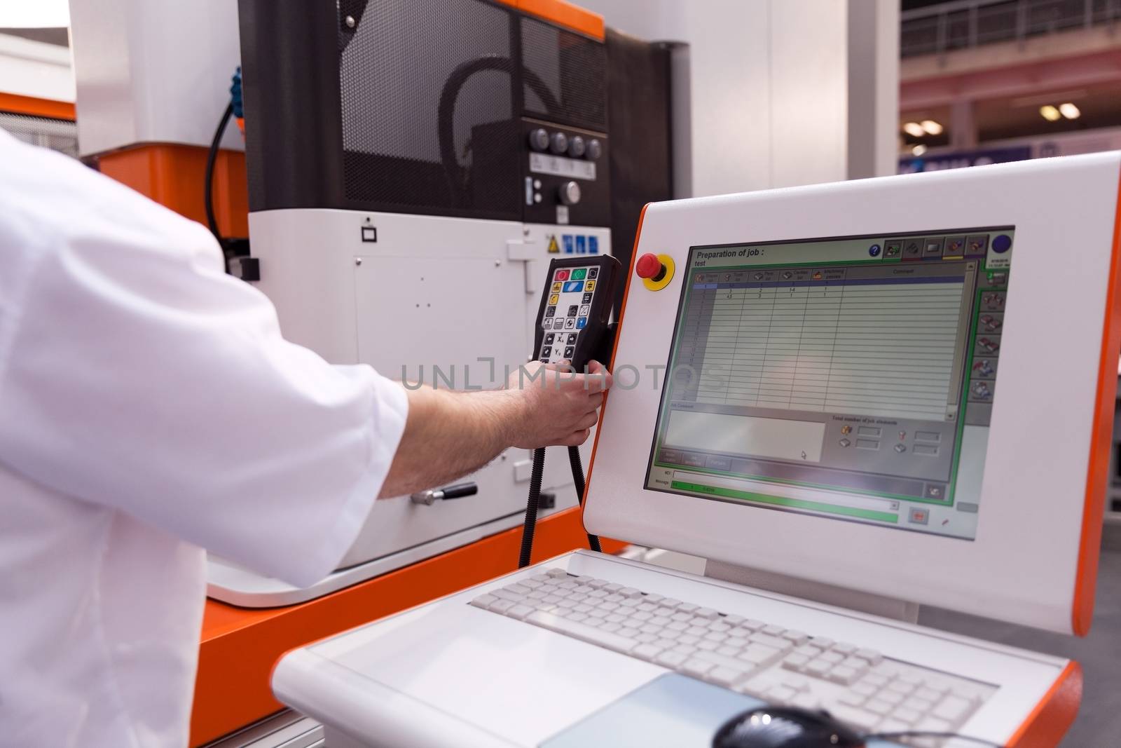 Technician working with computer numerical control (CNC) programmable machine. CNC technology.