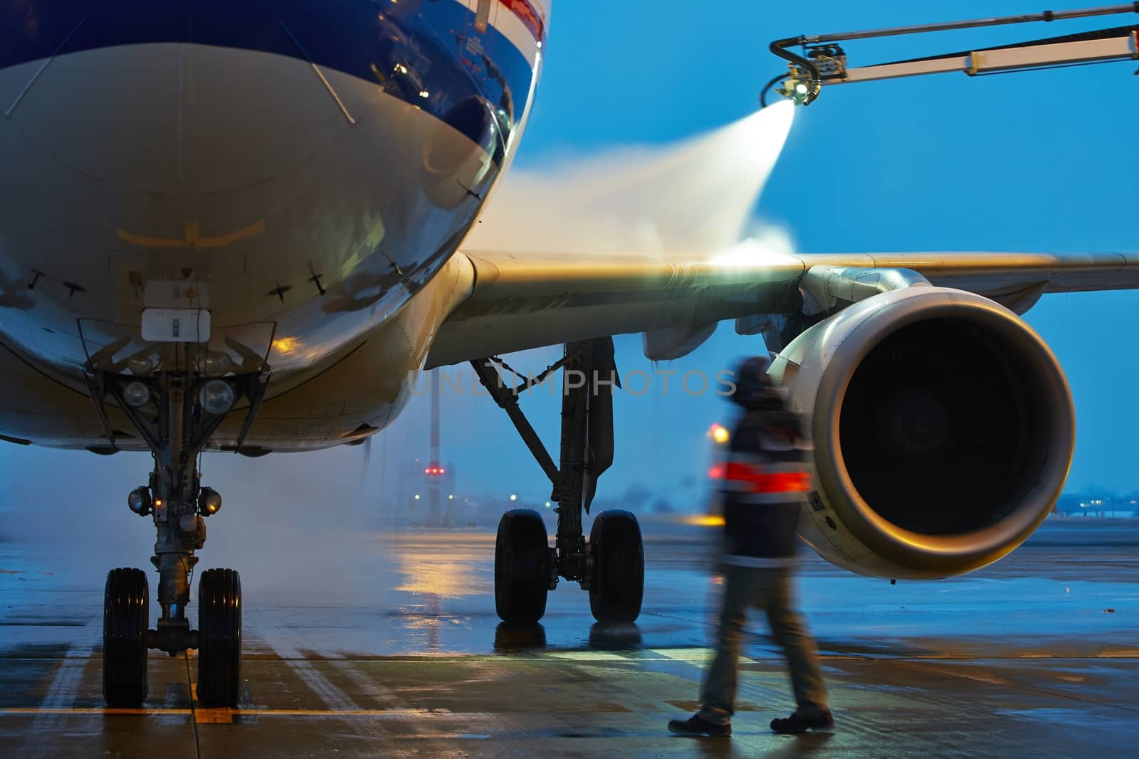 Winter time at the airport. Deicing of the airplane.