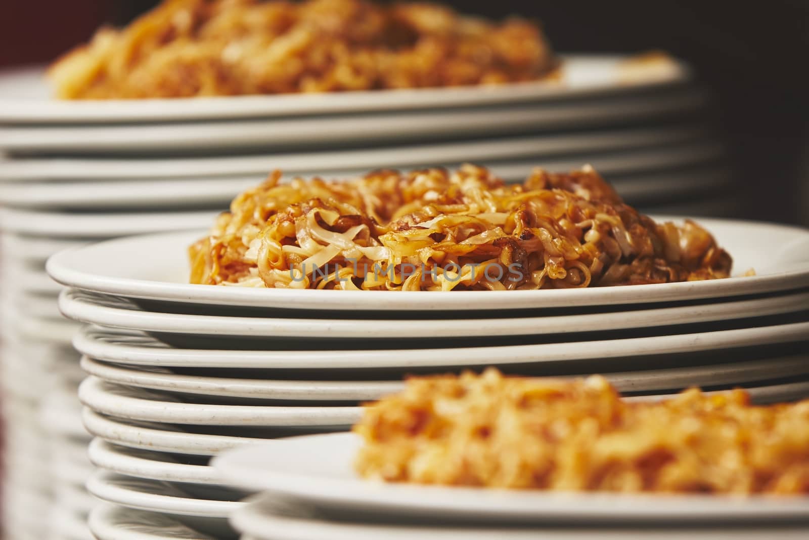 White plates with dinner stacked together - selective focus