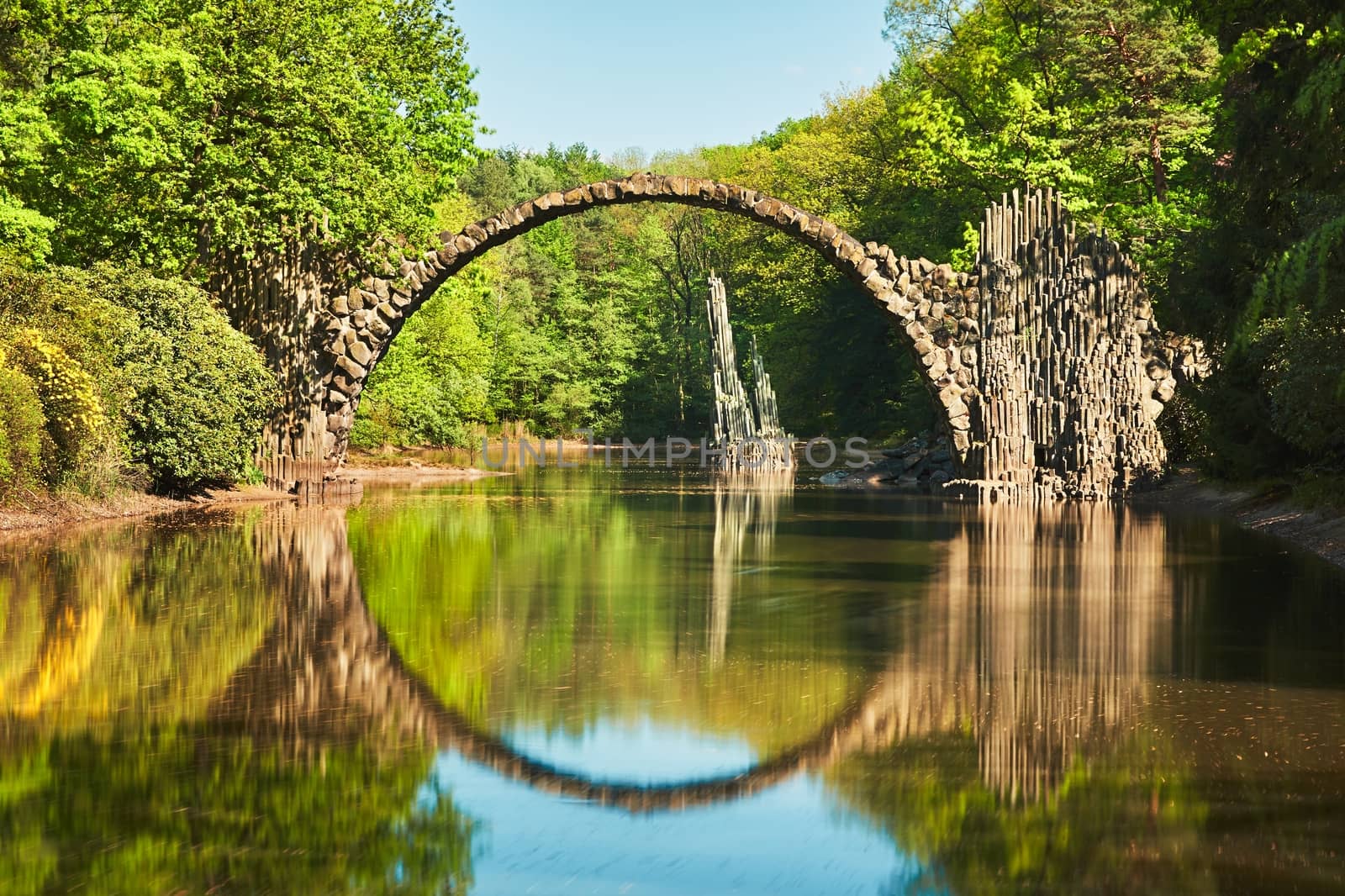 Amazing place in Germany - Rakotzbrucke also known as Devils Bridge in Kromlau. Reflection of the bridge in the water create a full circle.