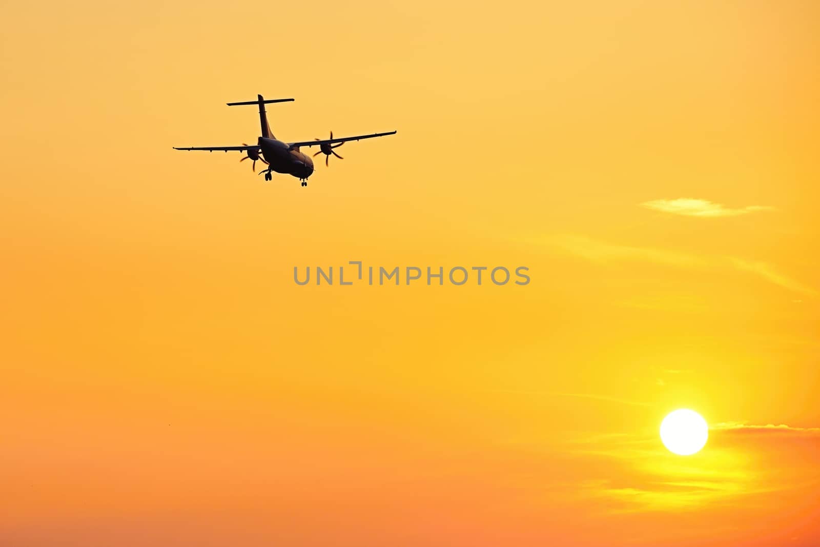 Silhouette of the airplane at the sunset 