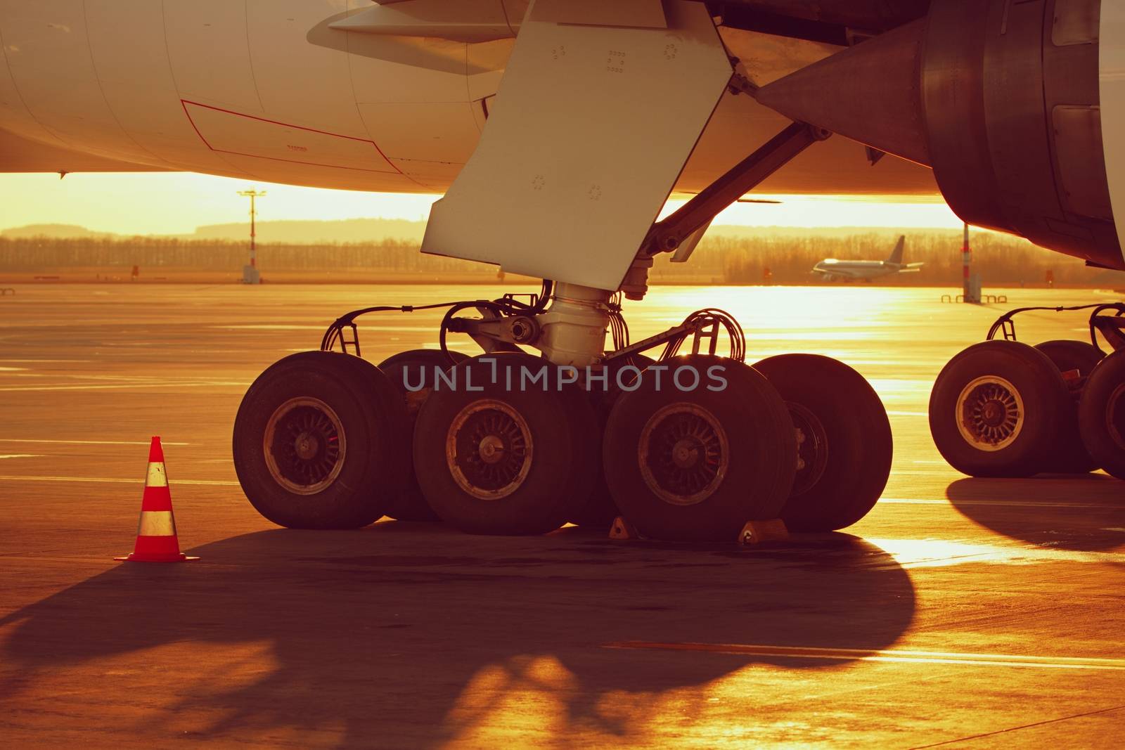 Undercarriage of the huge airplane at the sunset