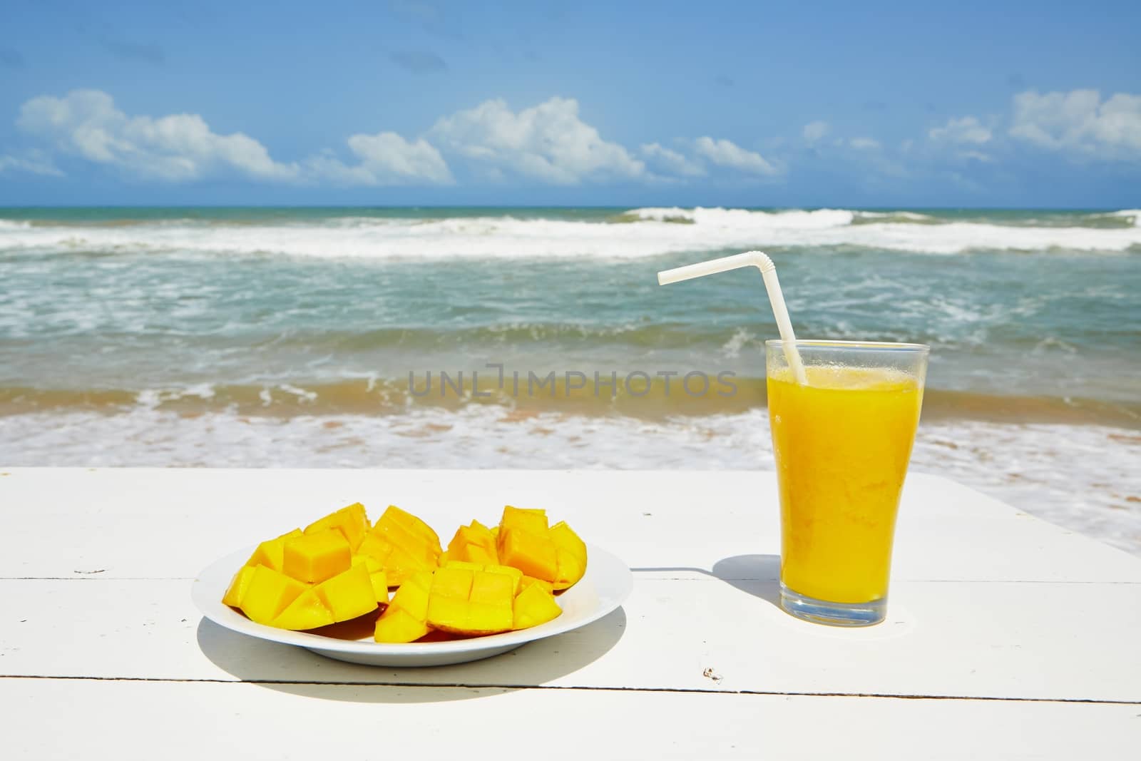 Fresh mango fruit and juice on the beach