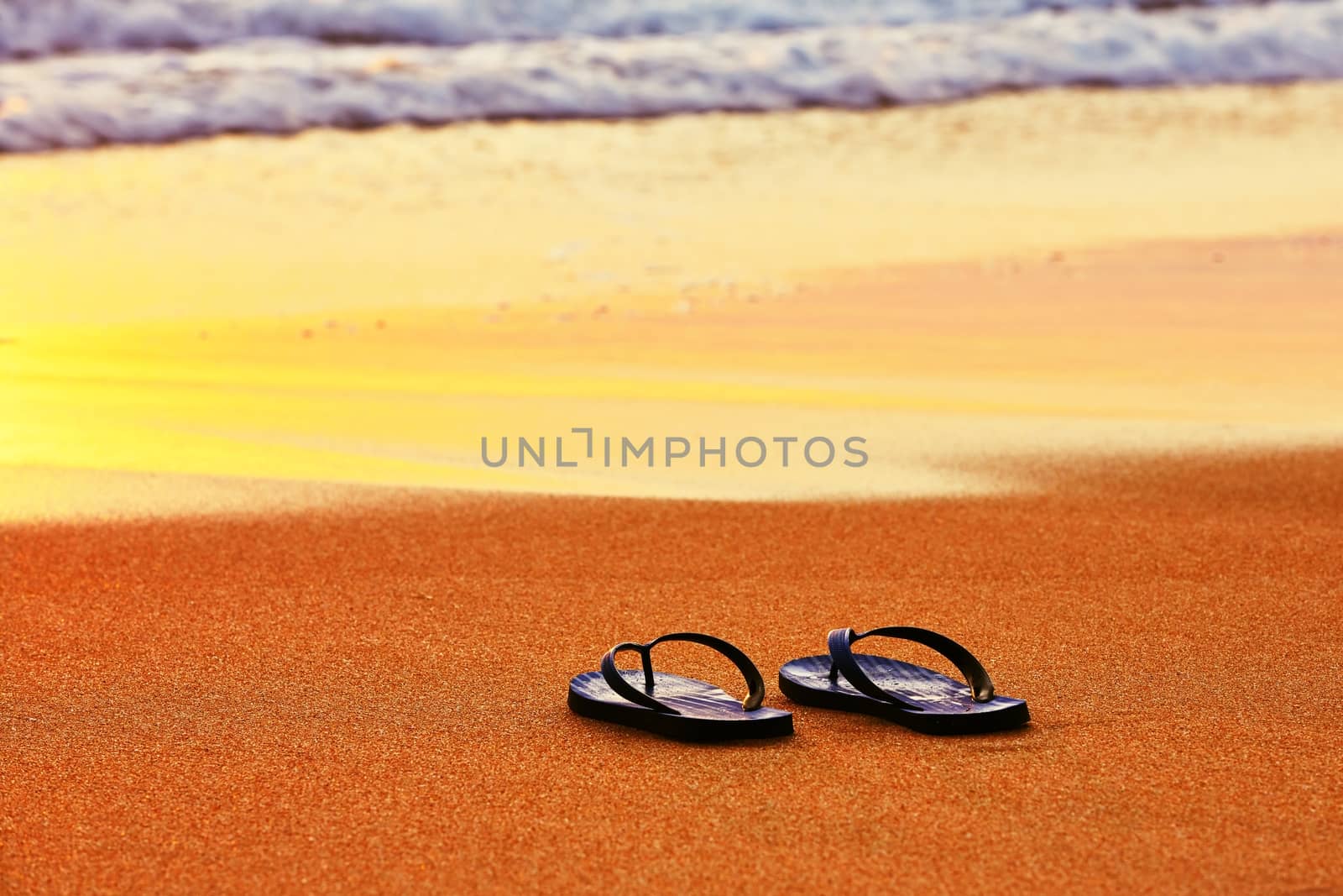 Flip flops on the beach at sunset
