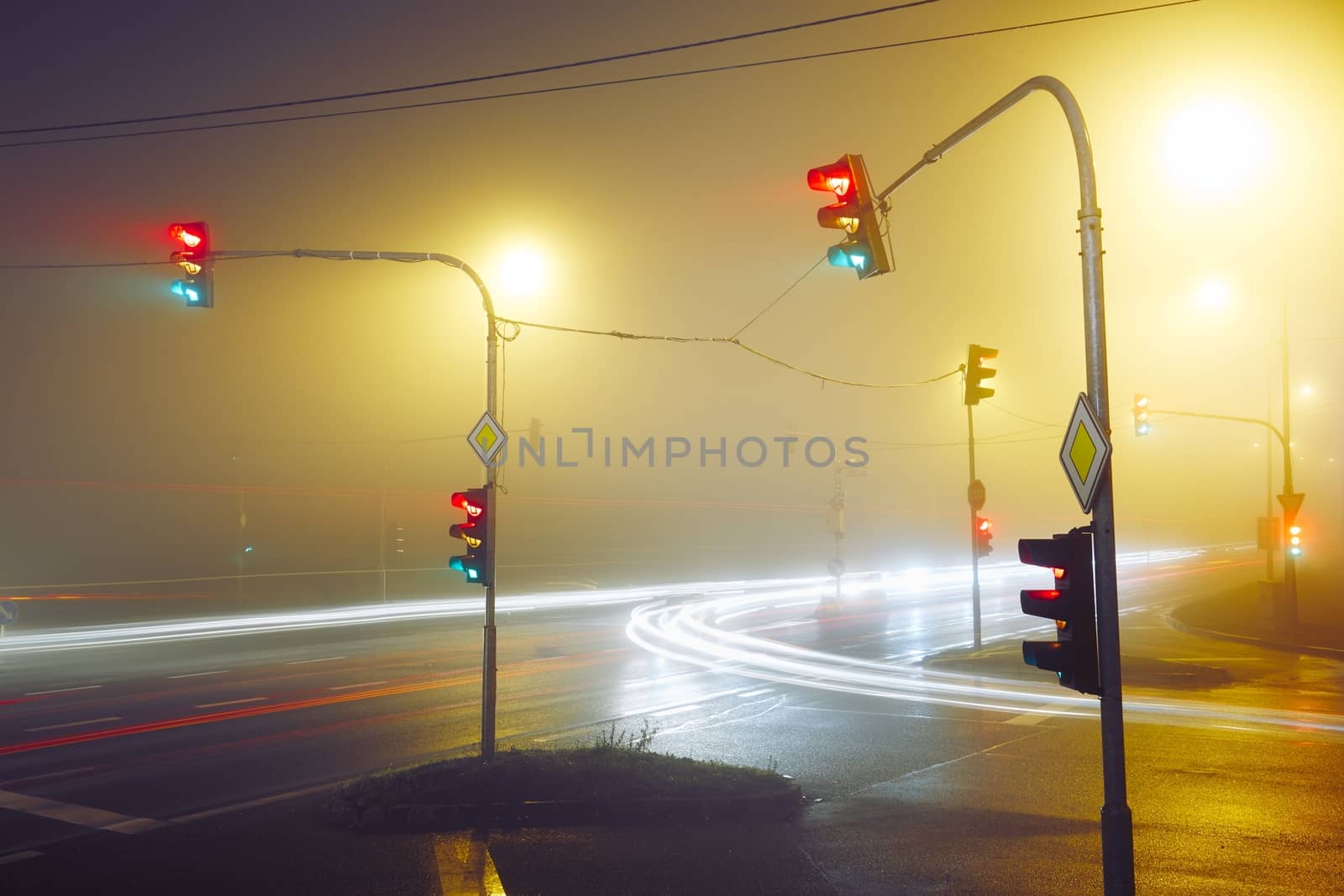 Traffic lights - crossroad in the foggy night
