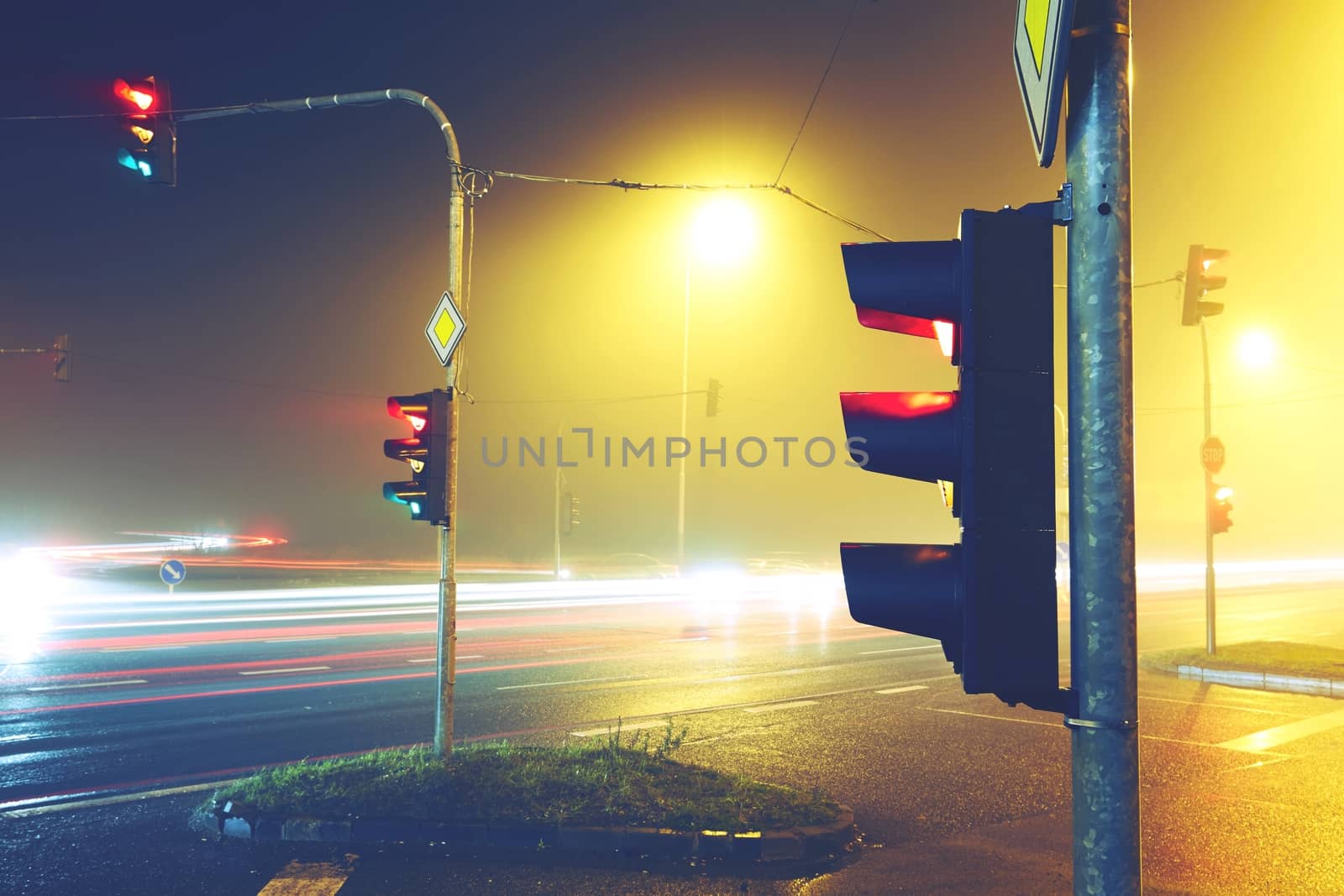 Traffic lights - crossroad in the foggy night