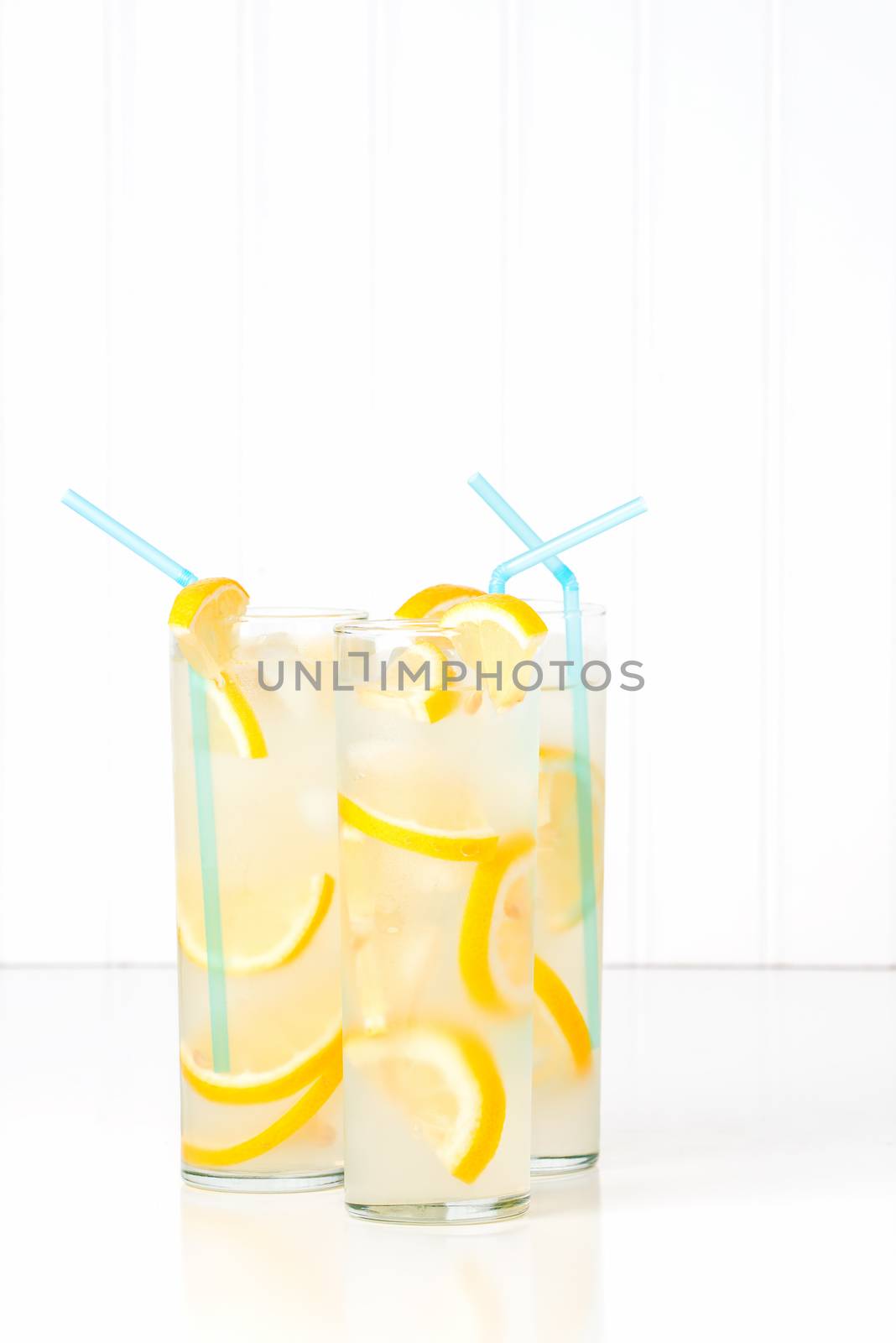 Three tall glasses of ice cold homemade lemonade.