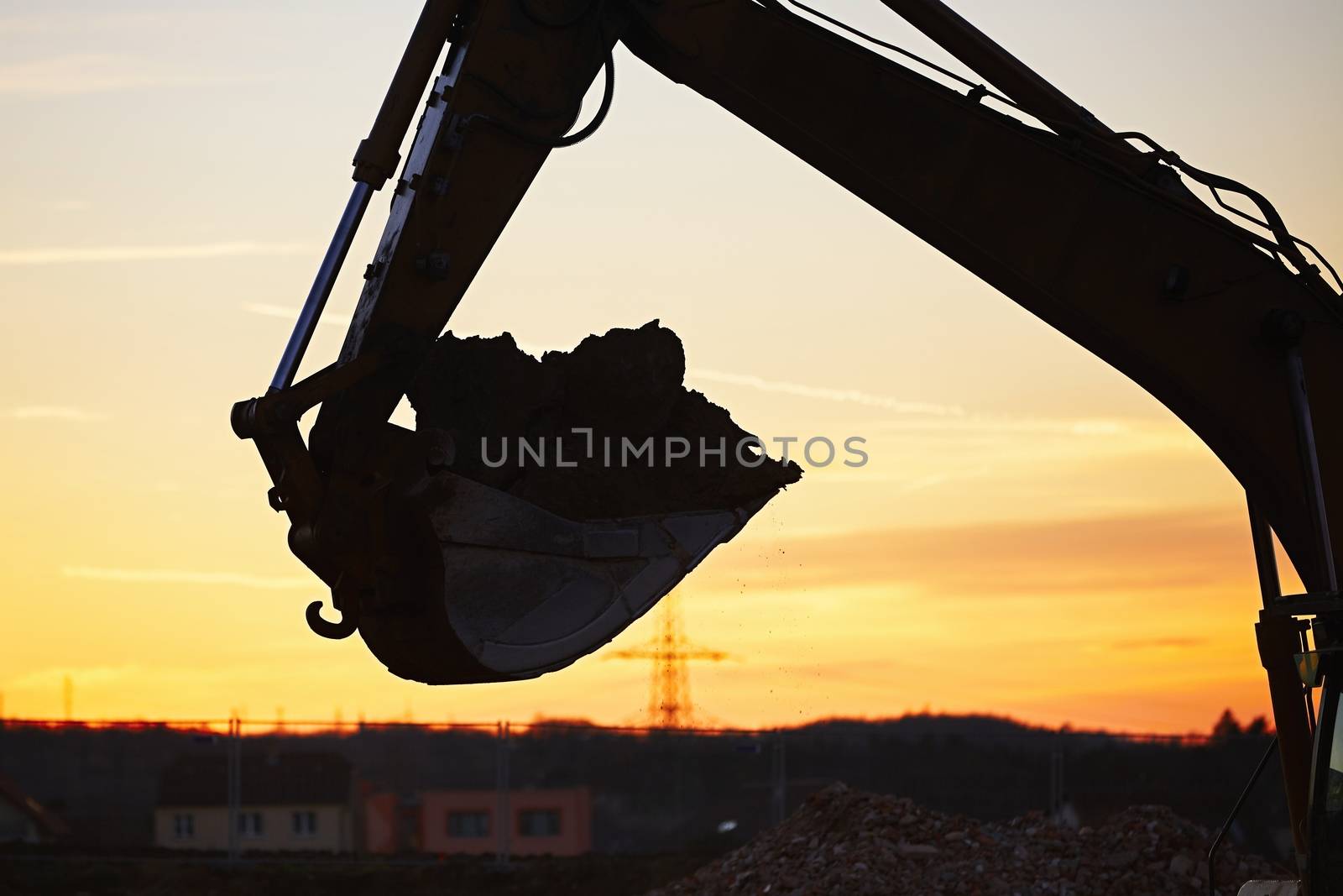 Silhouette of the backhoe in the building site