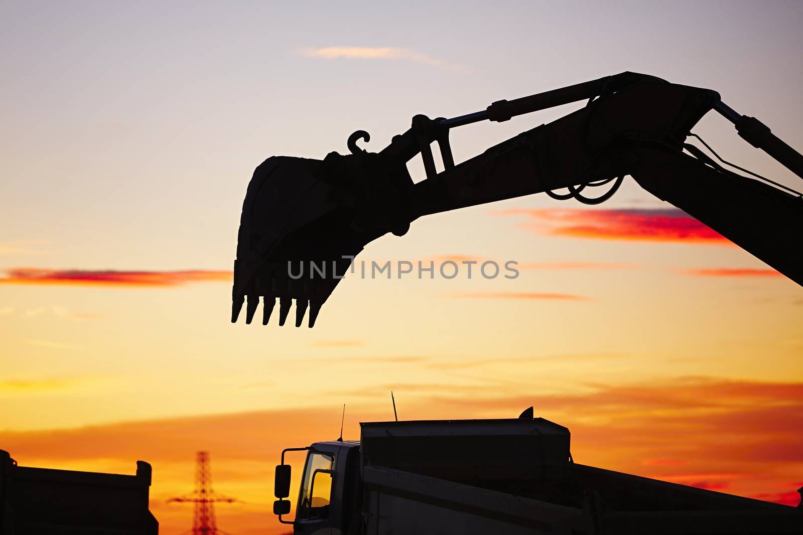 Silhouette of the backhoe in the building site