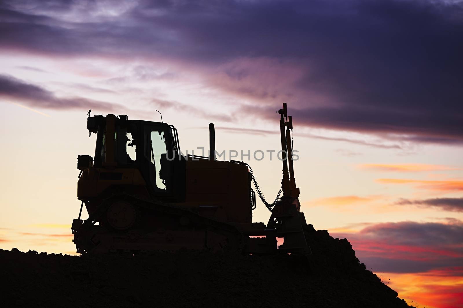 Silhouette of the bulldozer in the building site