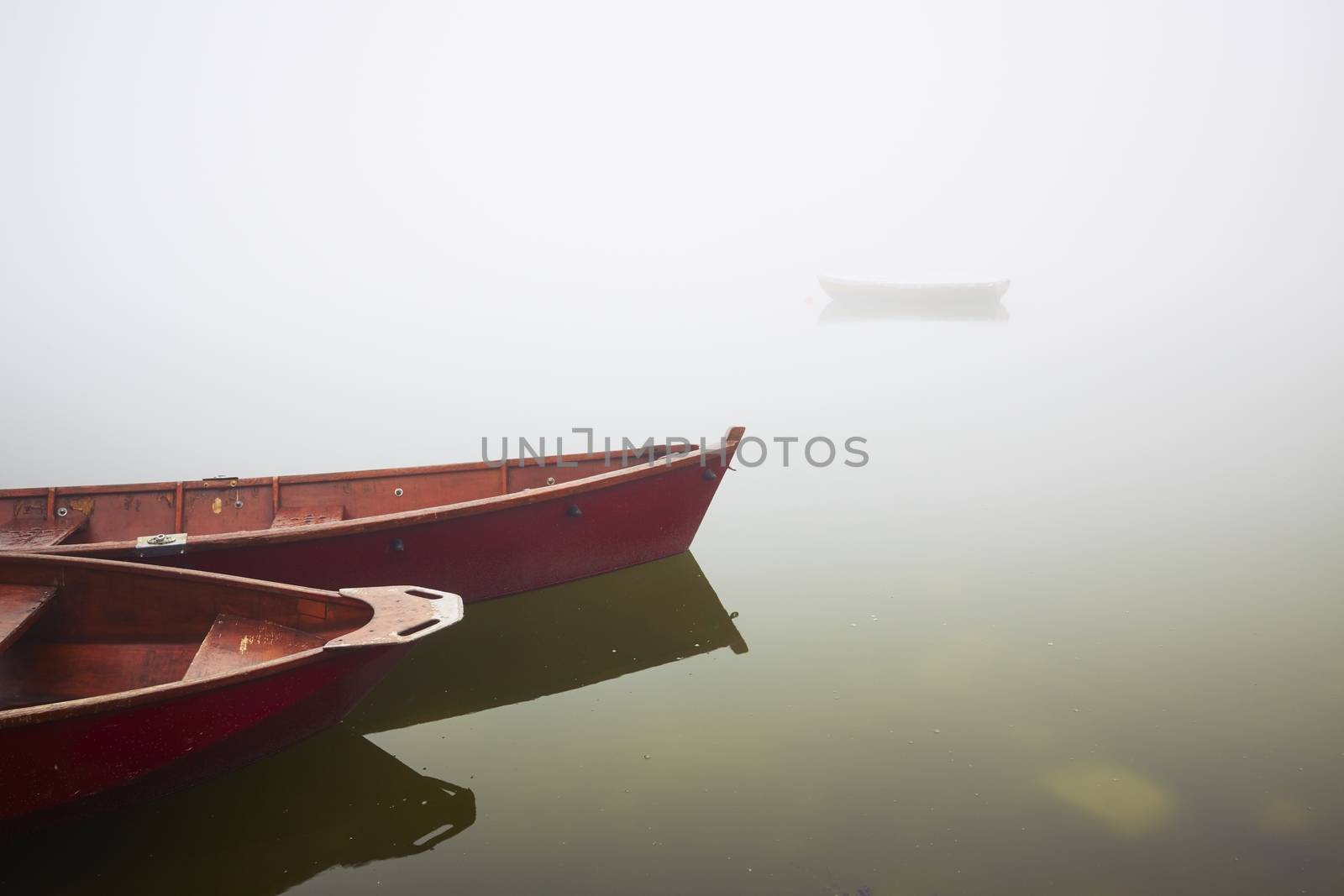 Boats on the lake at morning fog.