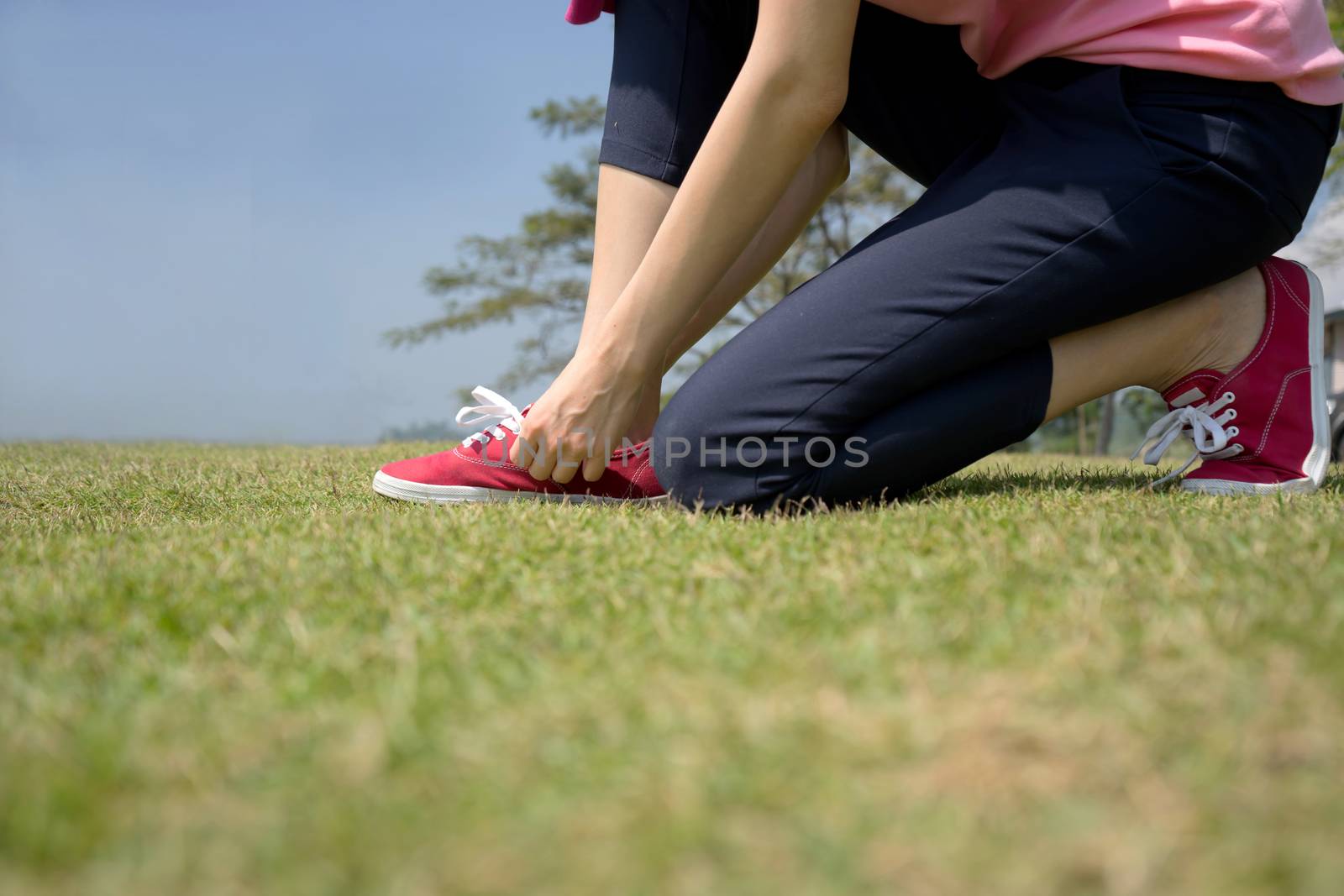 young asian woman tying shoelace