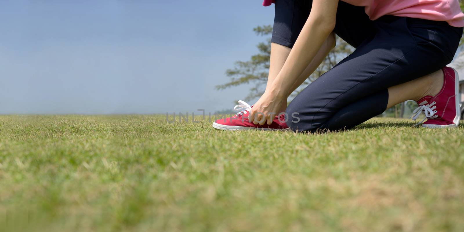 young asian woman tying shoelace

