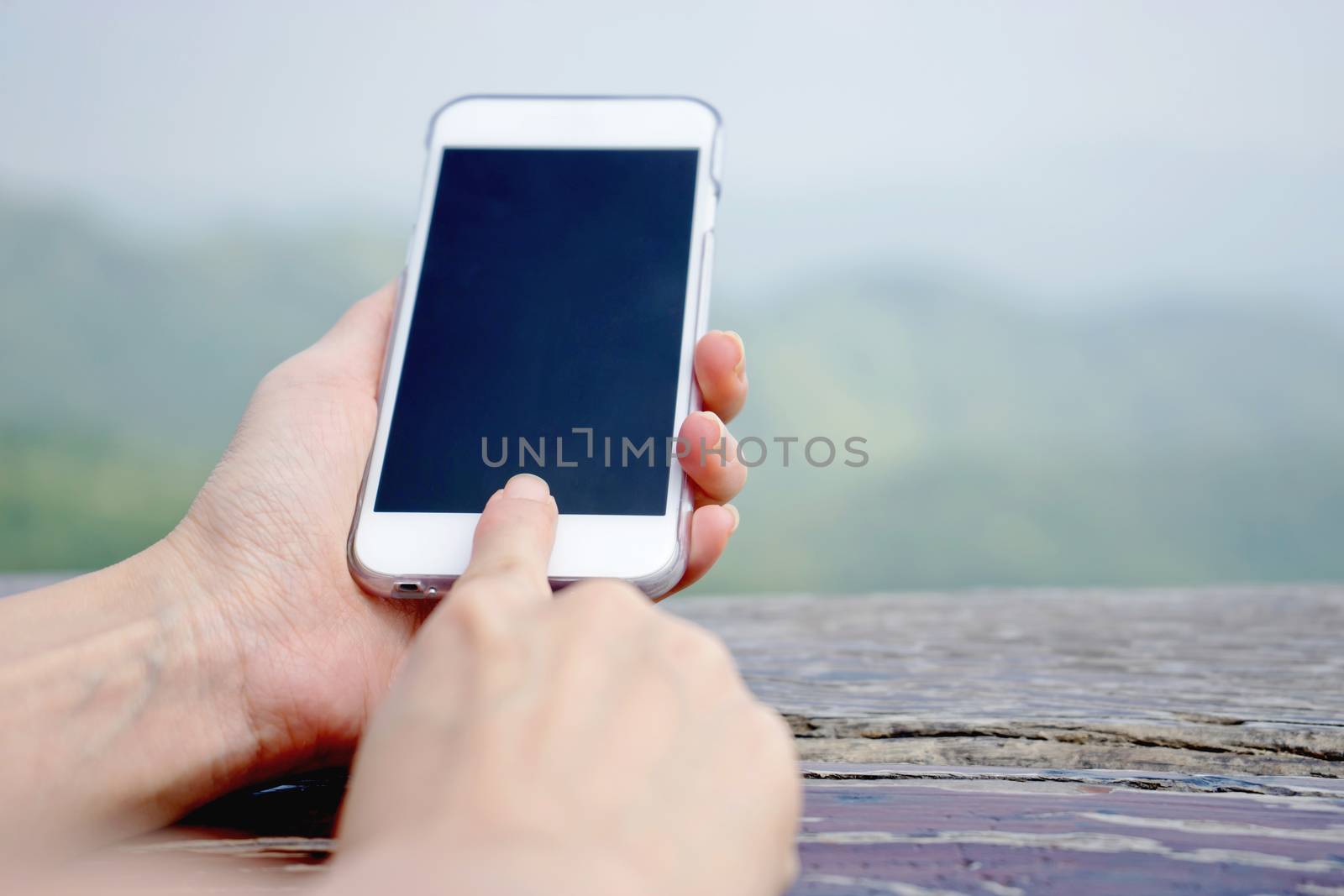 Closeup of female hand using a smart phone. Shallow depth of field