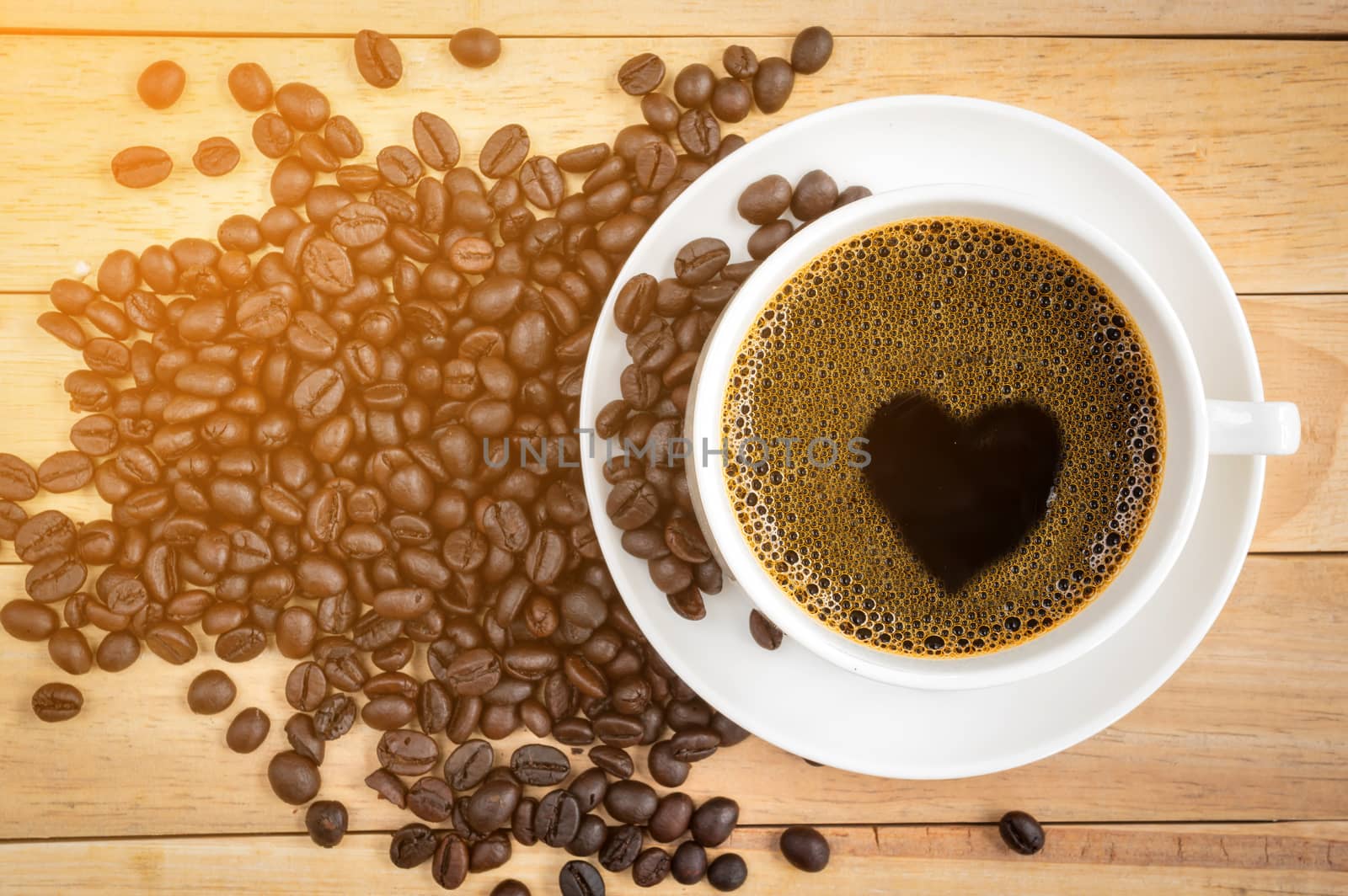 Cup of coffee with coffee bean on wood background.