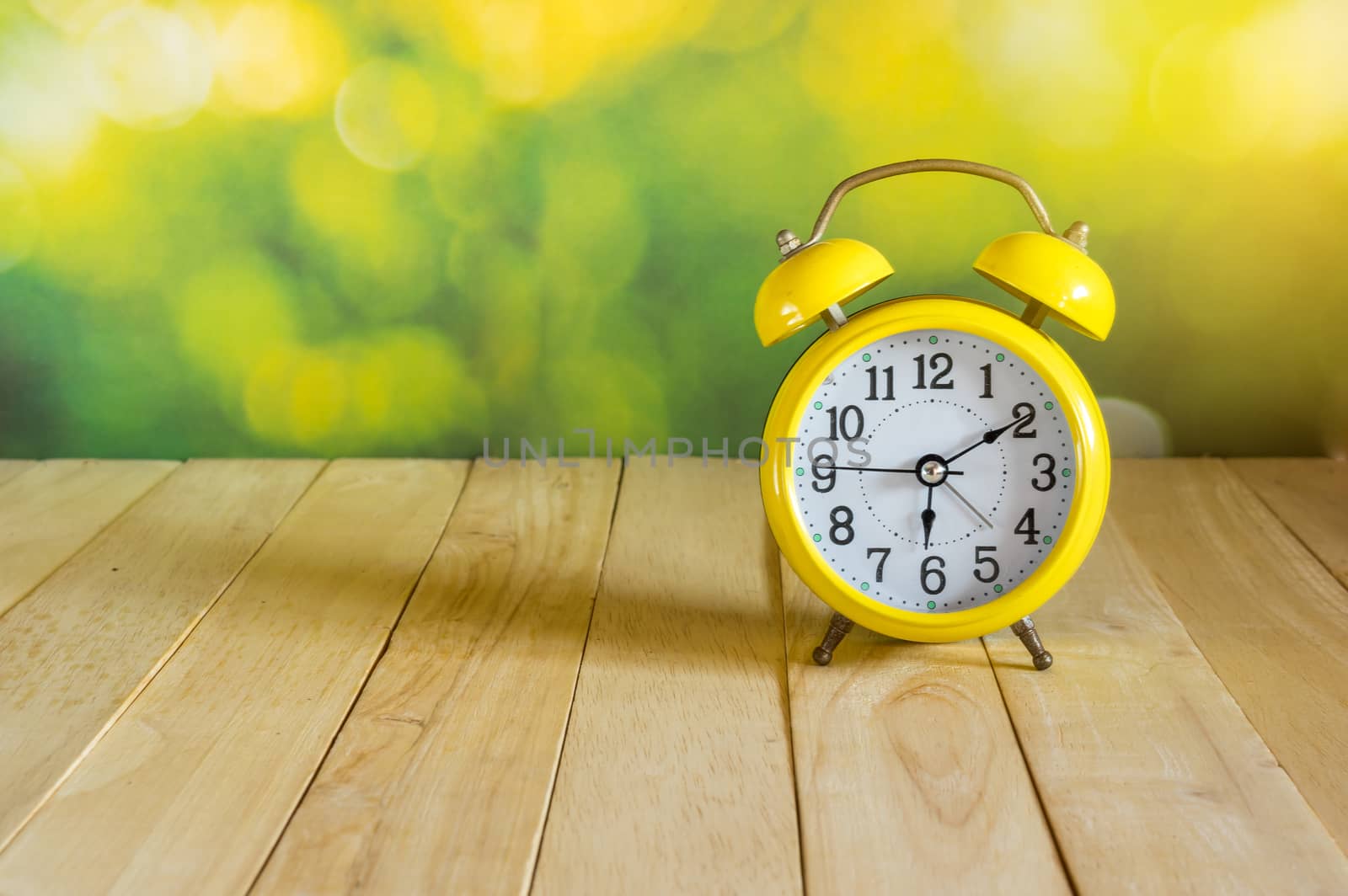 Yellow clock on wood table by seksan44
