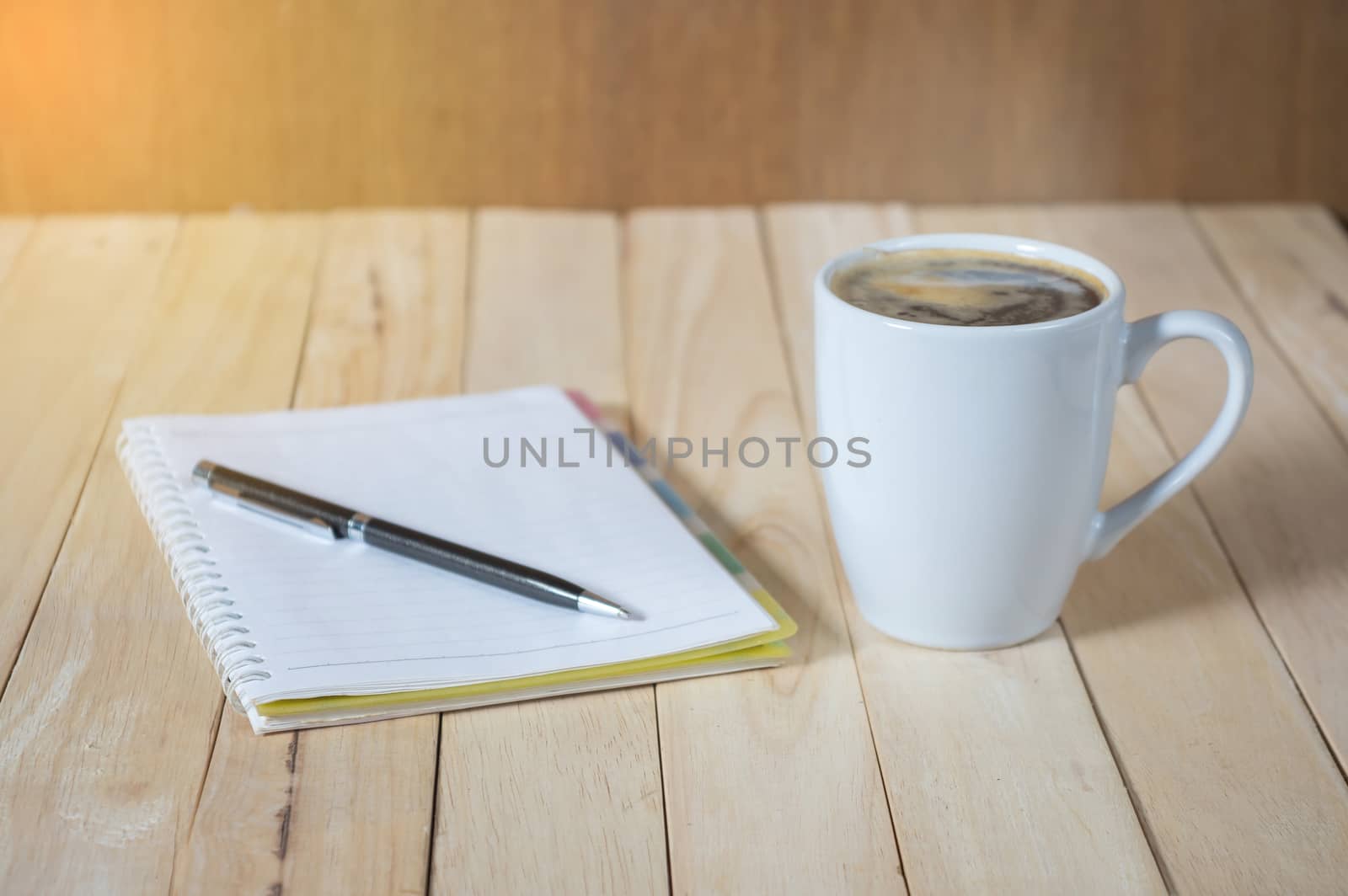 A cup of coffee on the table with calculator and notebook.