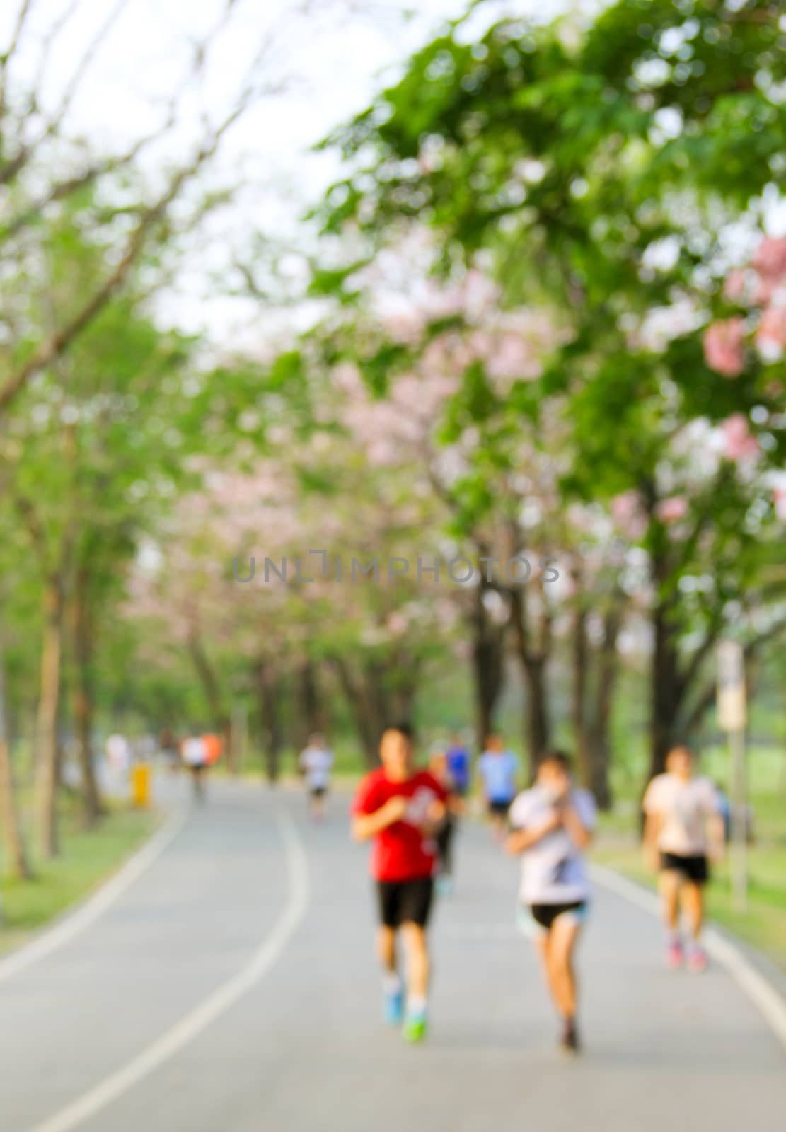 Blurred background of park with running people