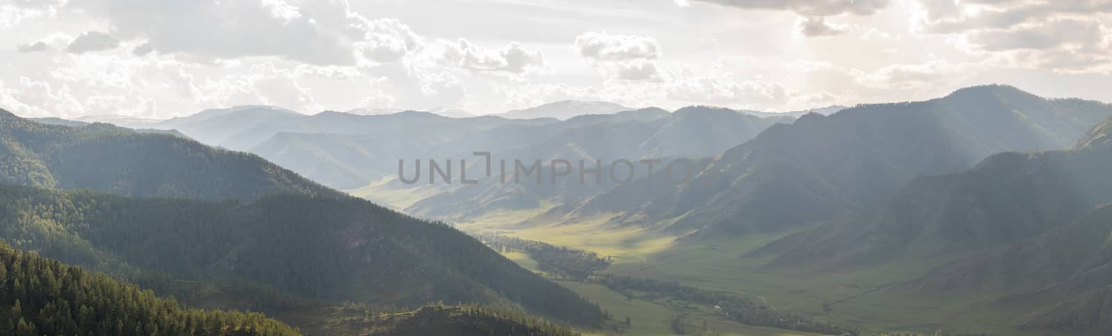 Mountain valley in the rays of the midday sun and fog by dpetrakov