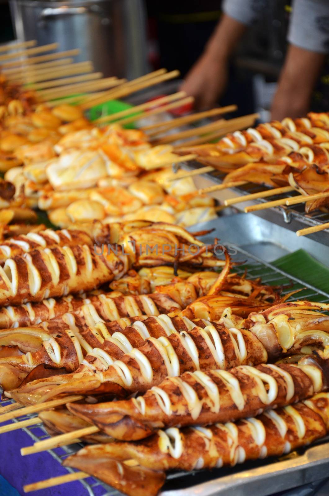 Grilled squids on stick, Thai street food.