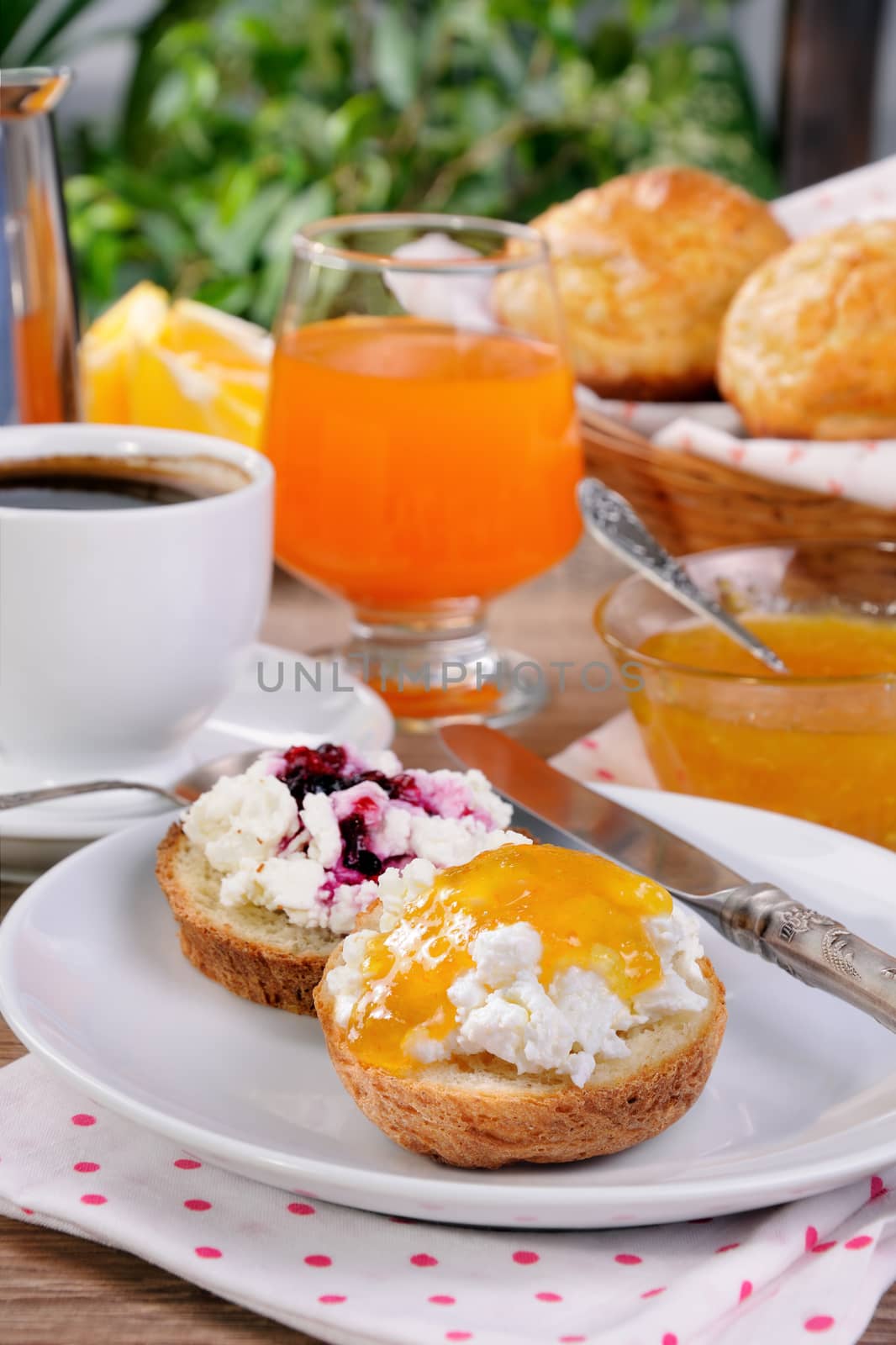Breakfast of bun with ricotta orange and cherry jam