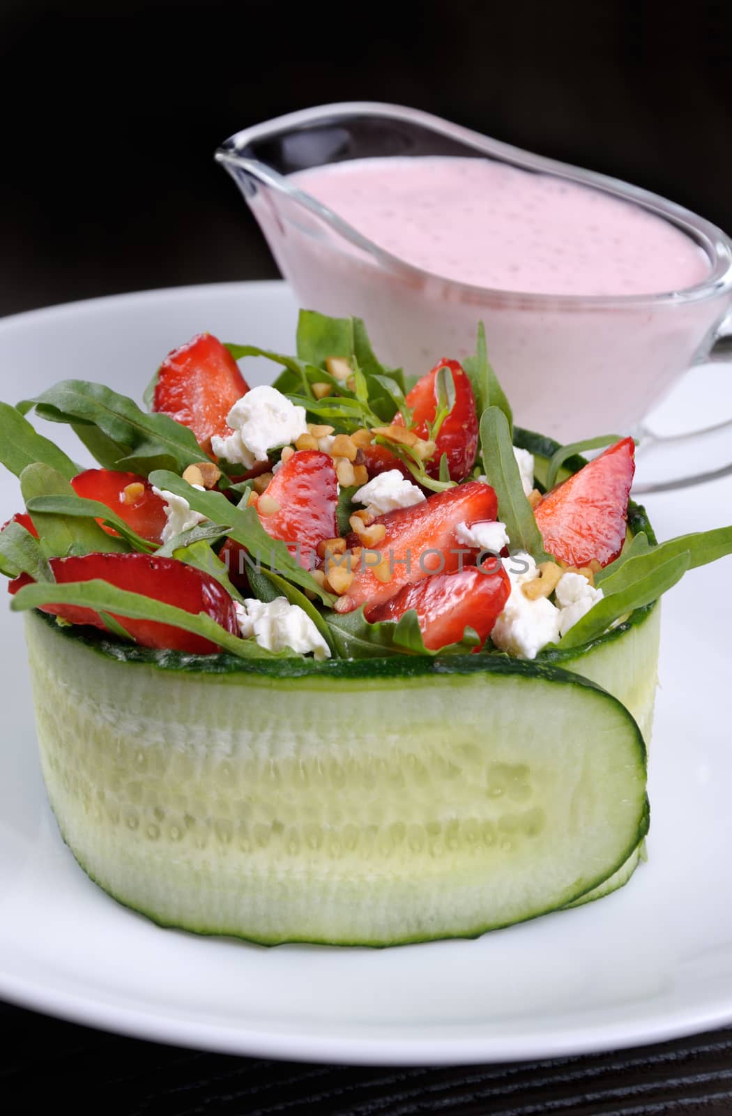 portion of strawberry salad with arugula and ricotta in cucumber