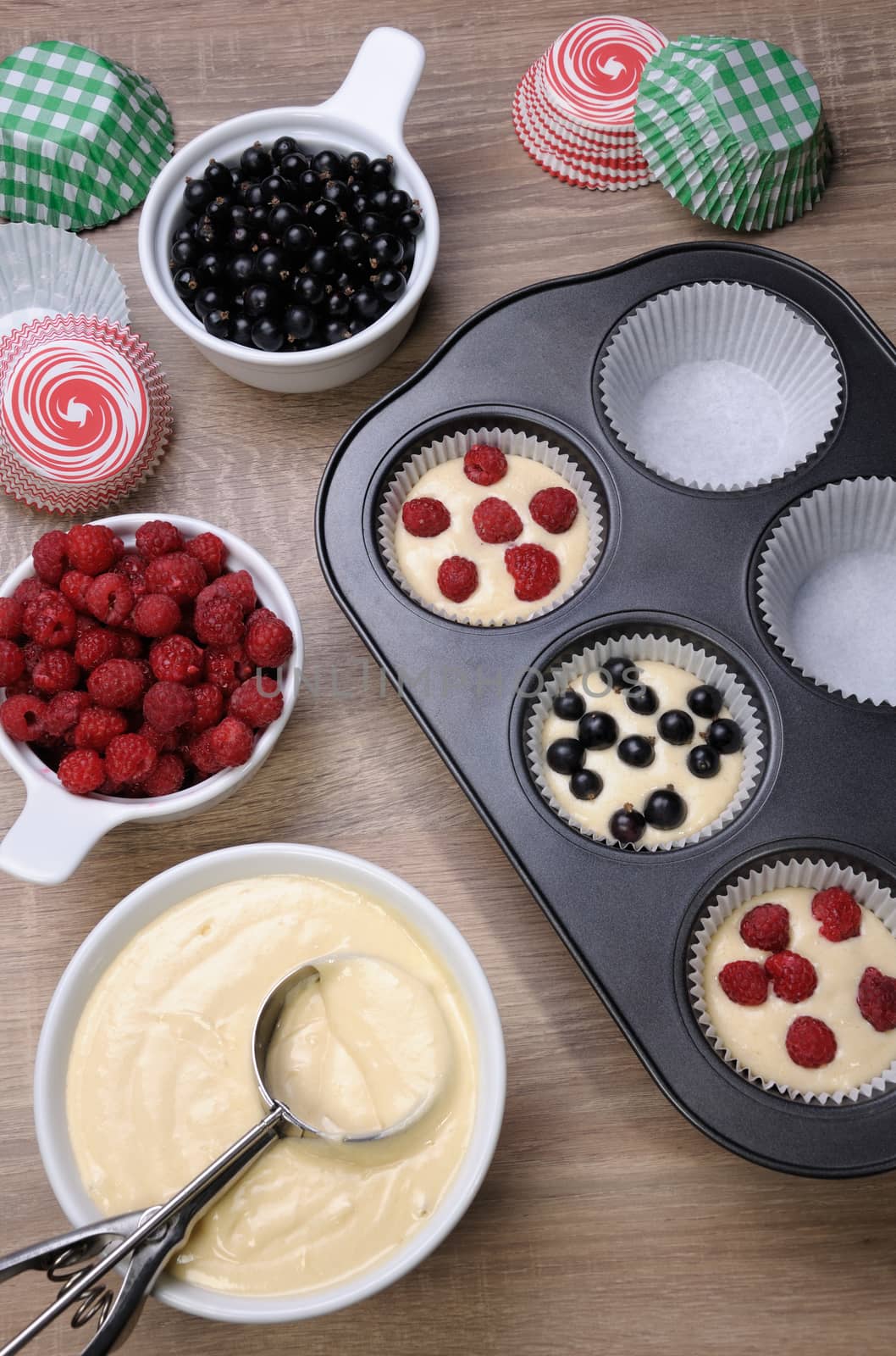 Preparation for baking muffins stuffed with raspberries and black currants
