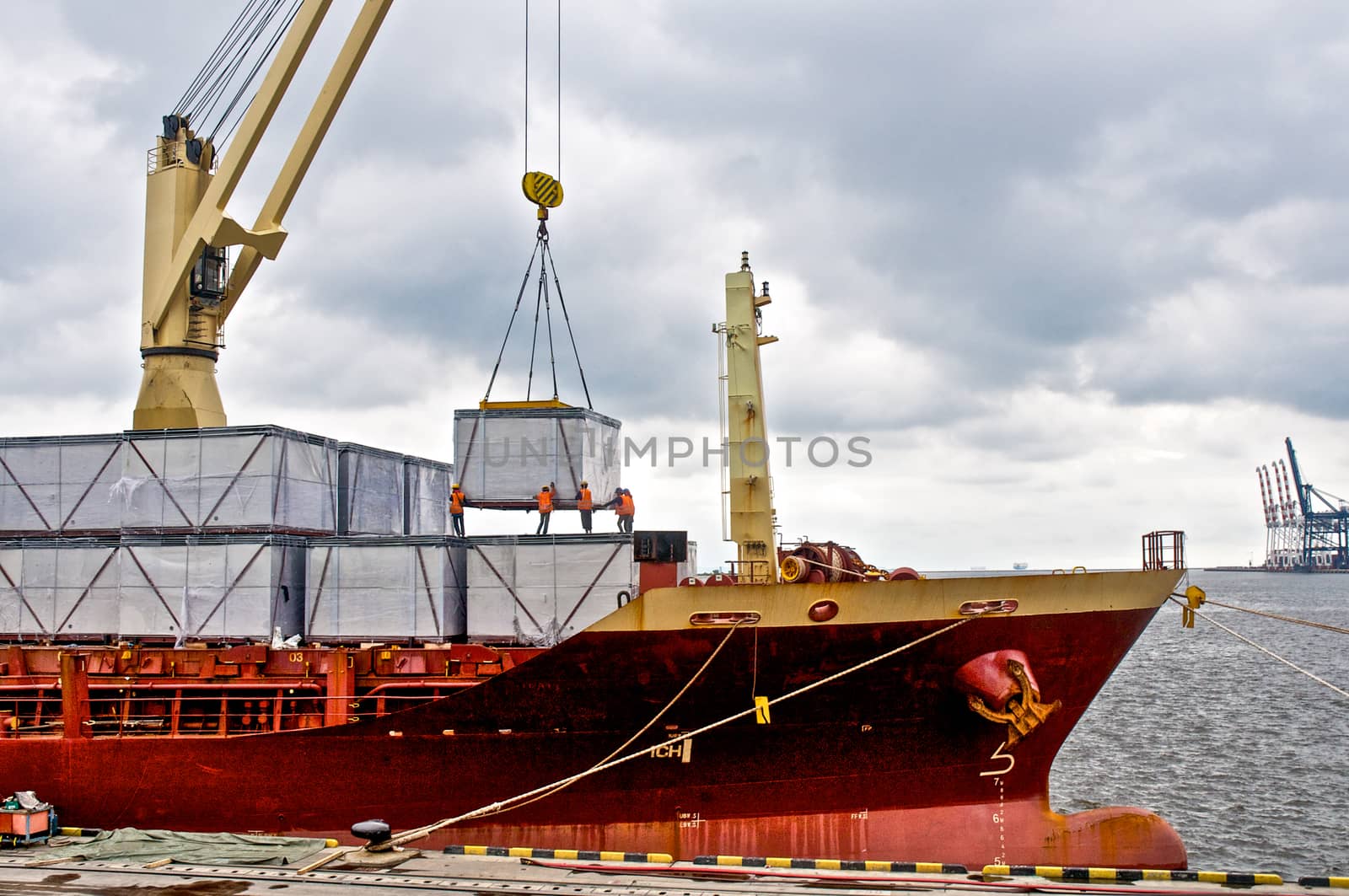 Cargo ship loading cargo into the ship in the harbor