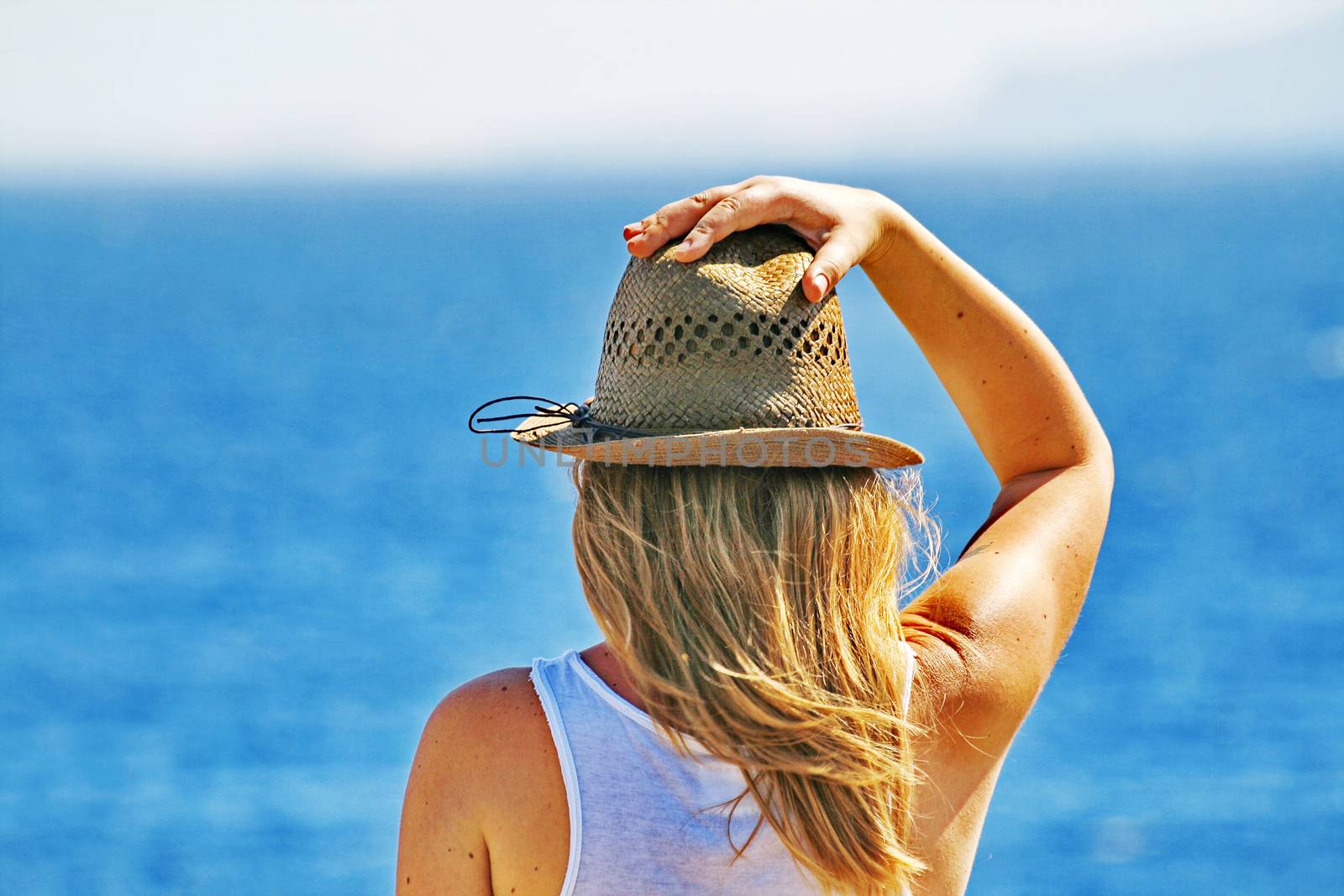 A young woman thoughtfully looks at a sea by Tanacha