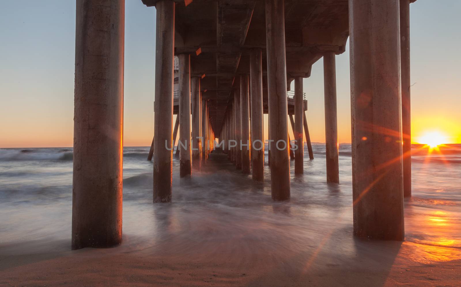 Under the Huntington Beach Pier in Huntington Beach, California, United States at sunset in the fall