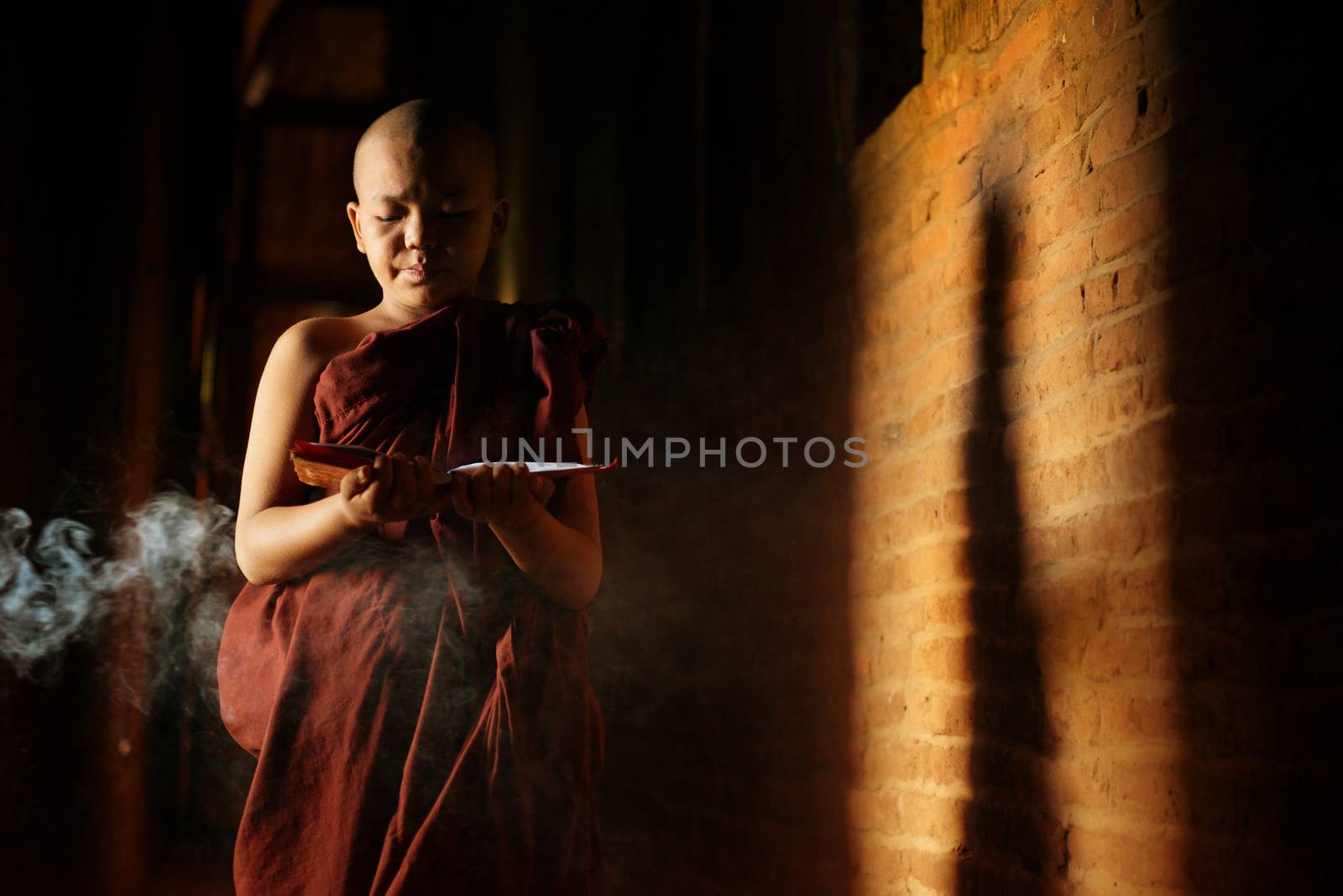 Young novice monk learning inside monastery.