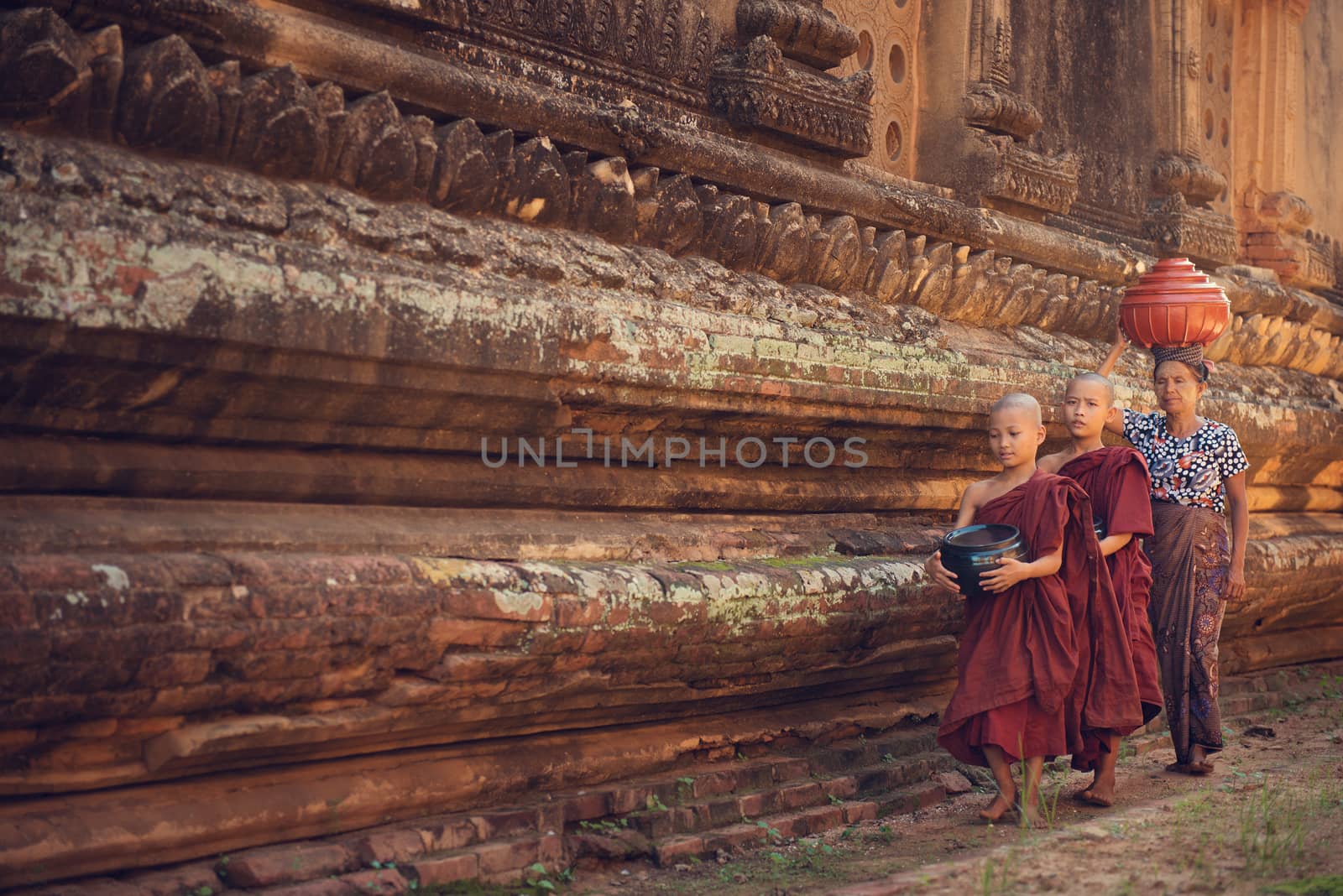 Young Buddhist novice monks walking morning alms in Old Bagan, Myanmar