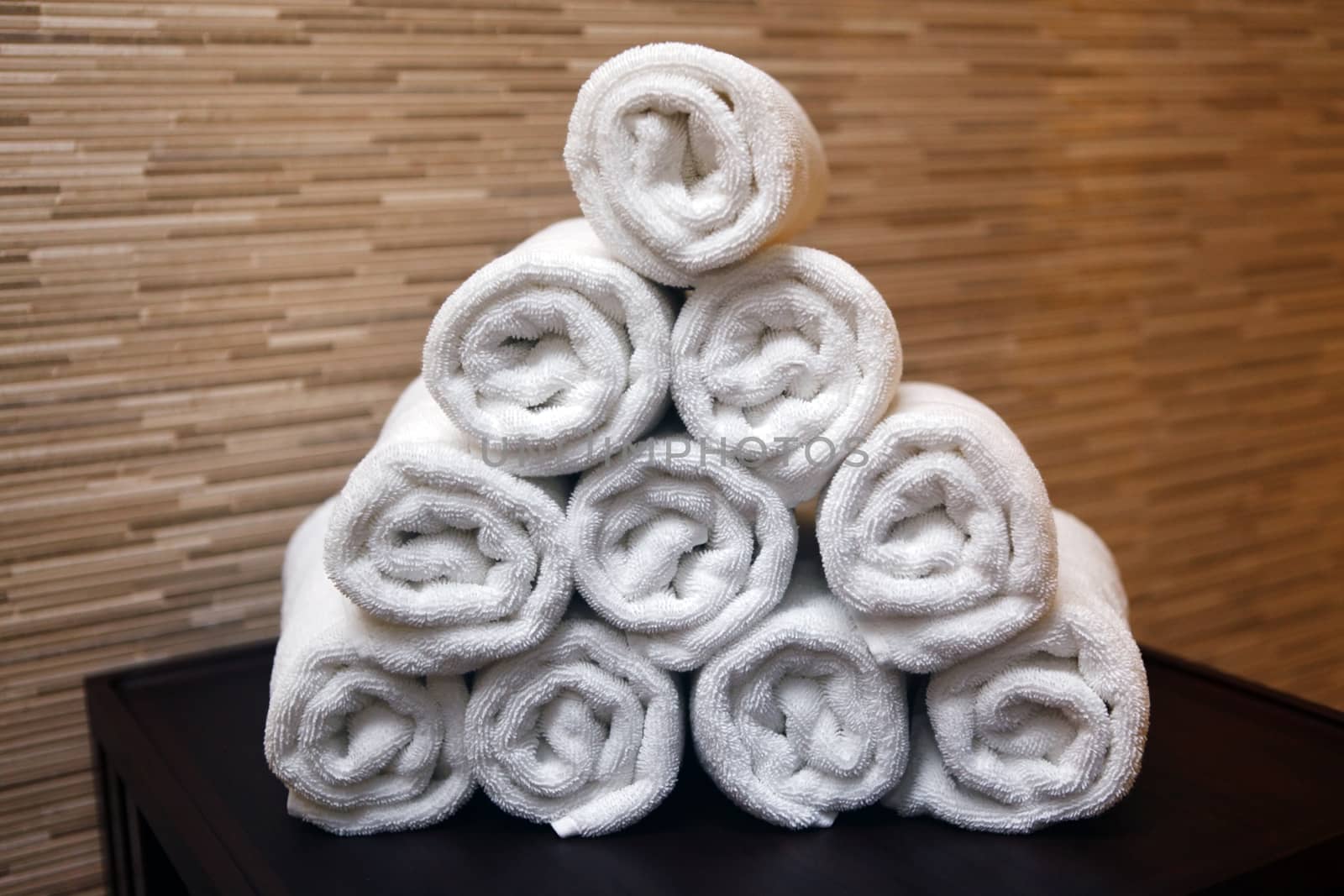 Freshly washed rolled towels isolated on wall