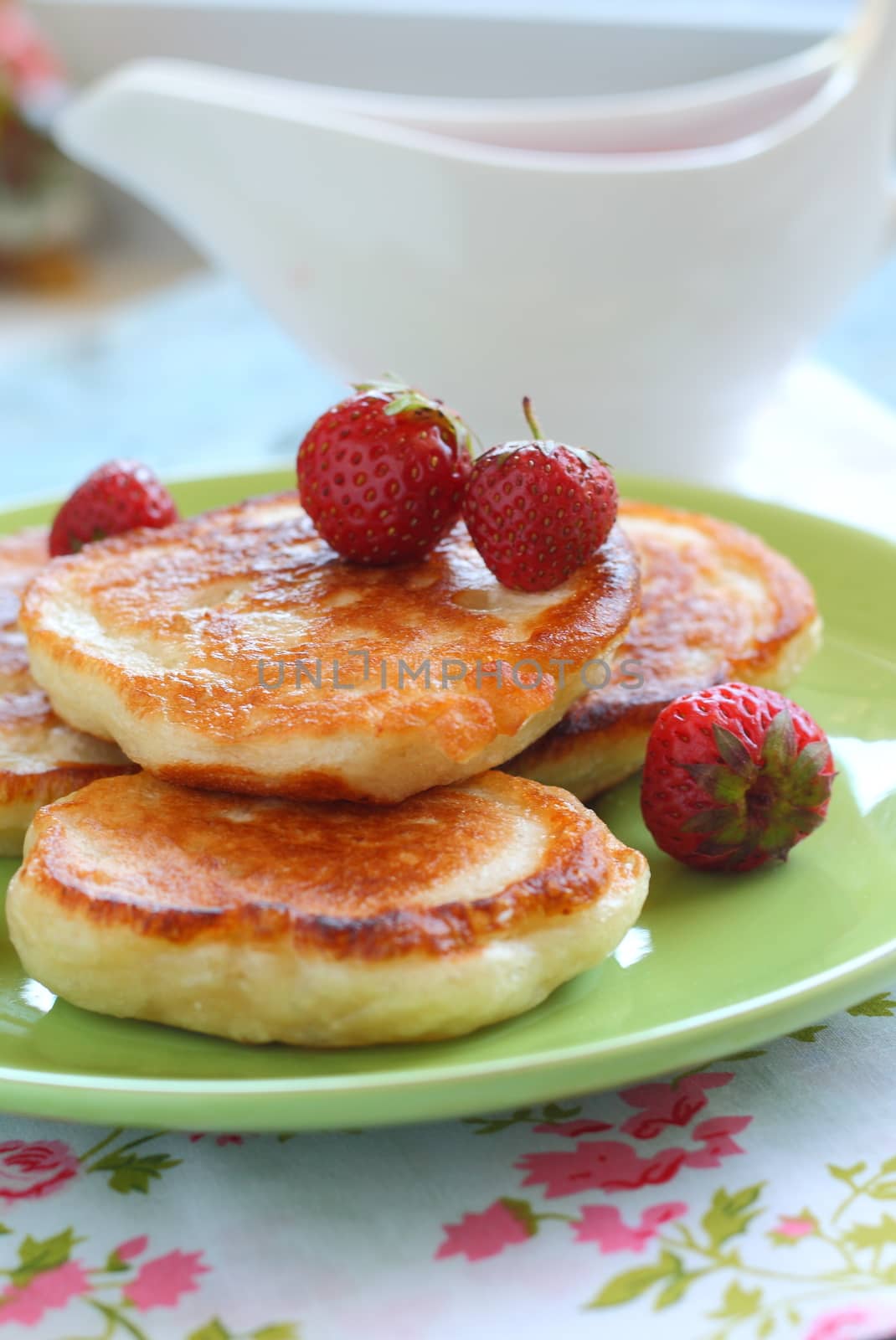 Breakfast serving of pancakes with strawberries and strawberry sauce in a pot in the style of a romantic