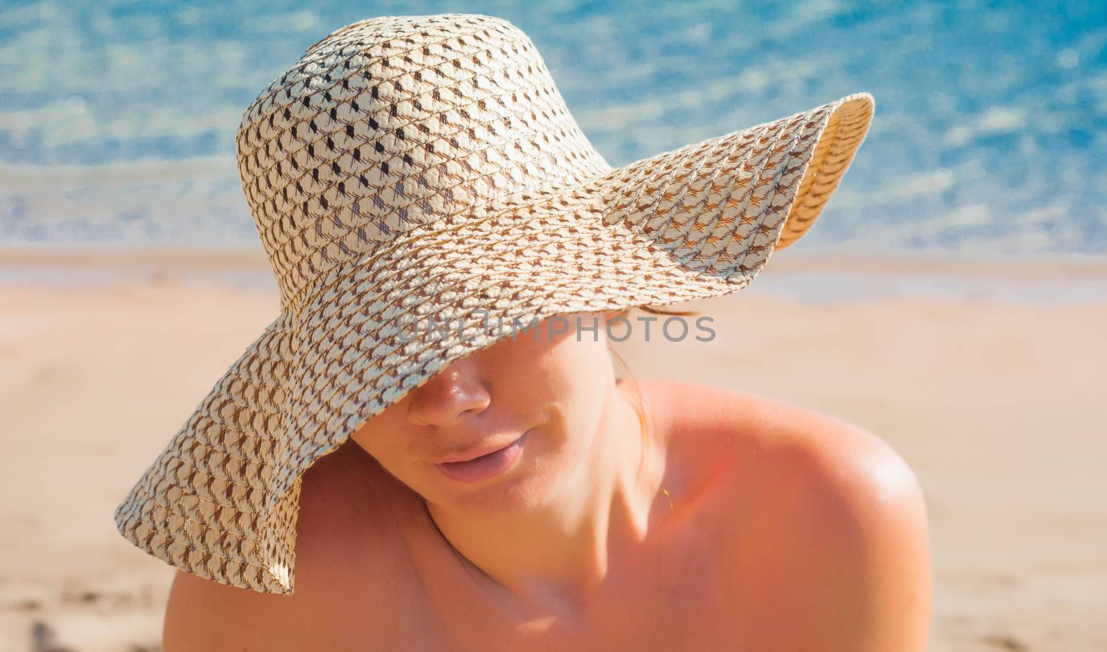 Young woman in a straw broad-brimmed hat, part of the face cover by Tanacha