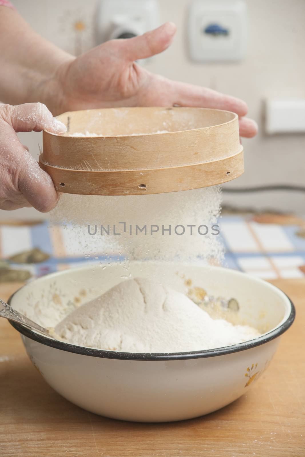 Women's hands preparing flour before baking pie.