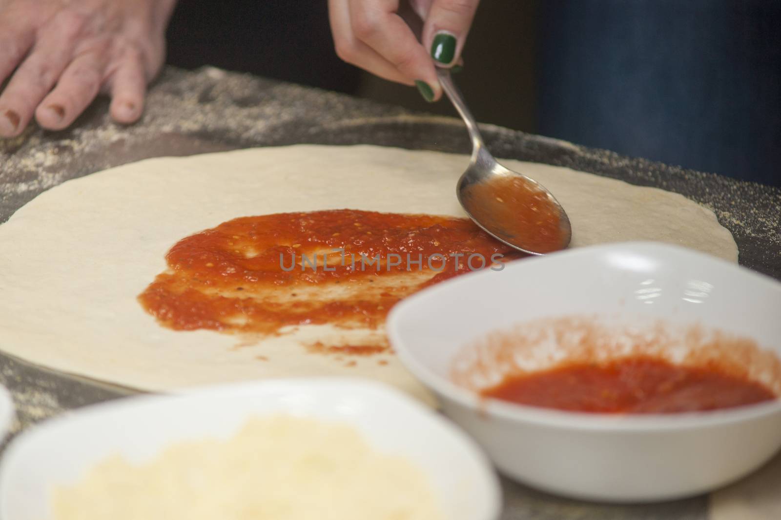 Woman chef with raw dough. Young female in uniform preparing bread dough on table.