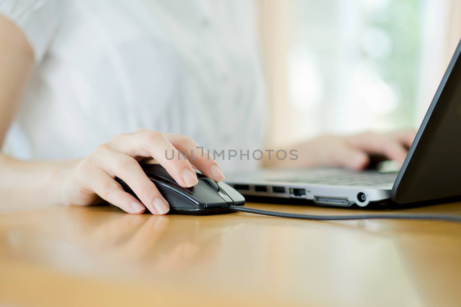 Image of female hands clicking computer mouse