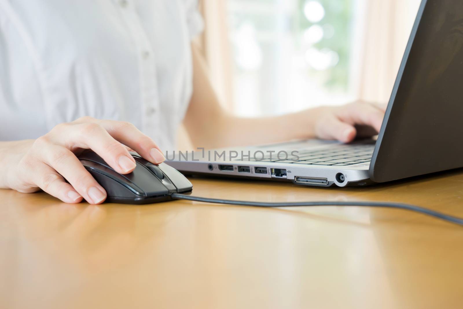 Image of female hands clicking computer mouse