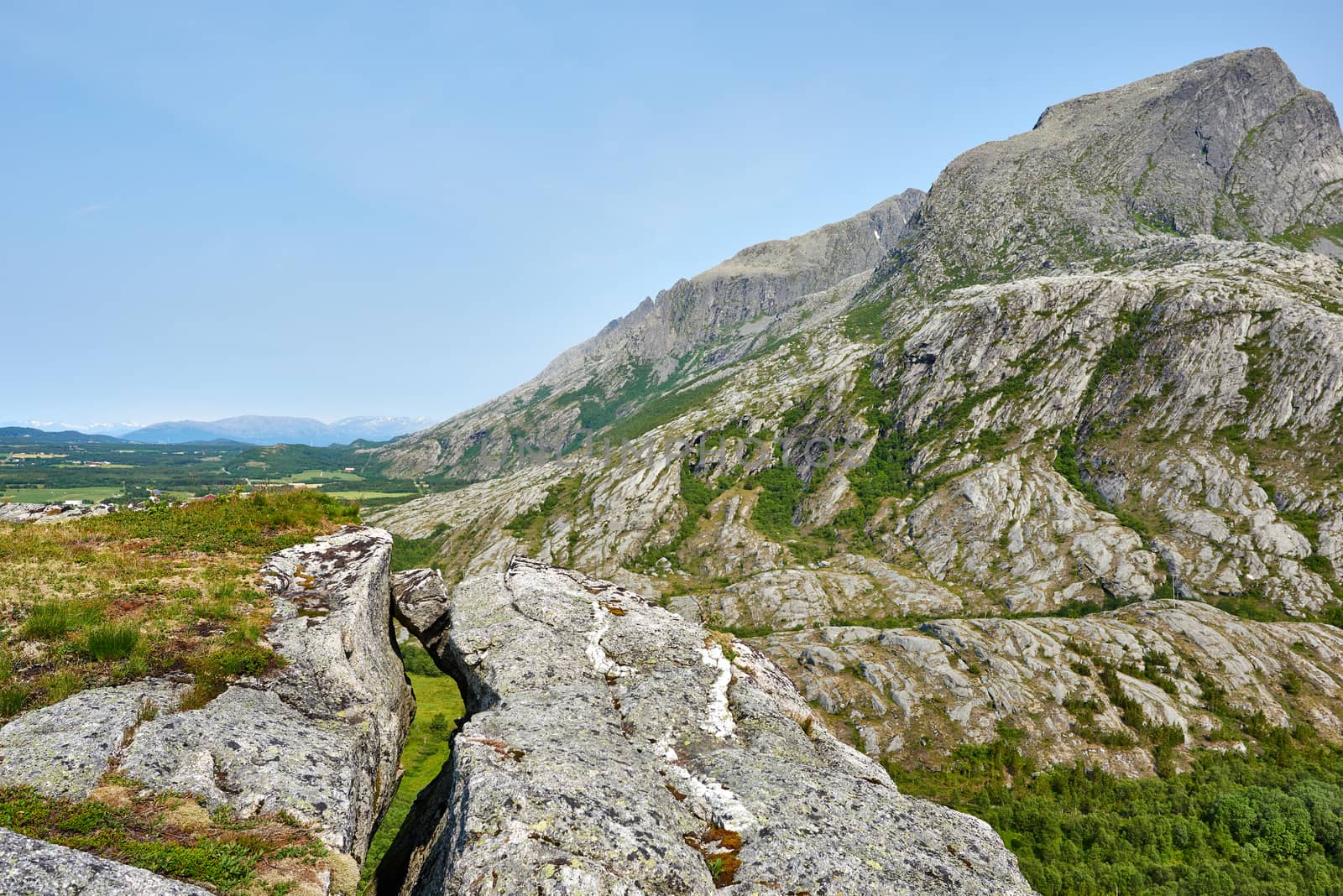 A rock stuck between a big crack in a mountain. 