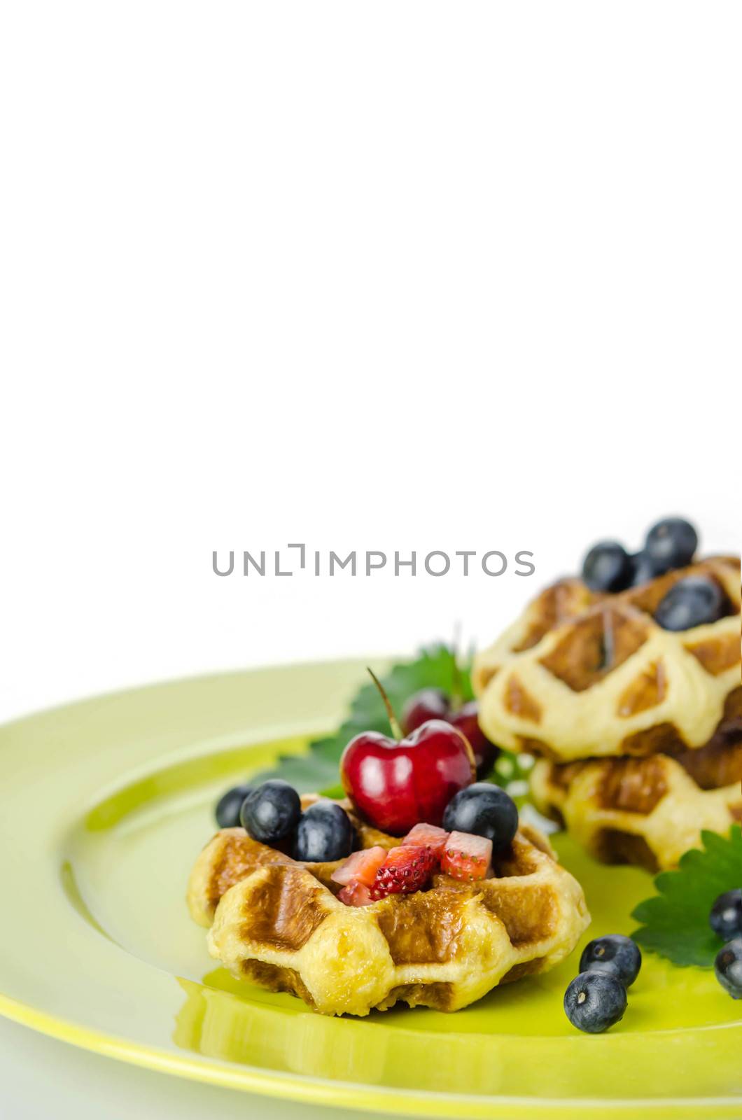 Homemade waffles with mix berries fruit on white background